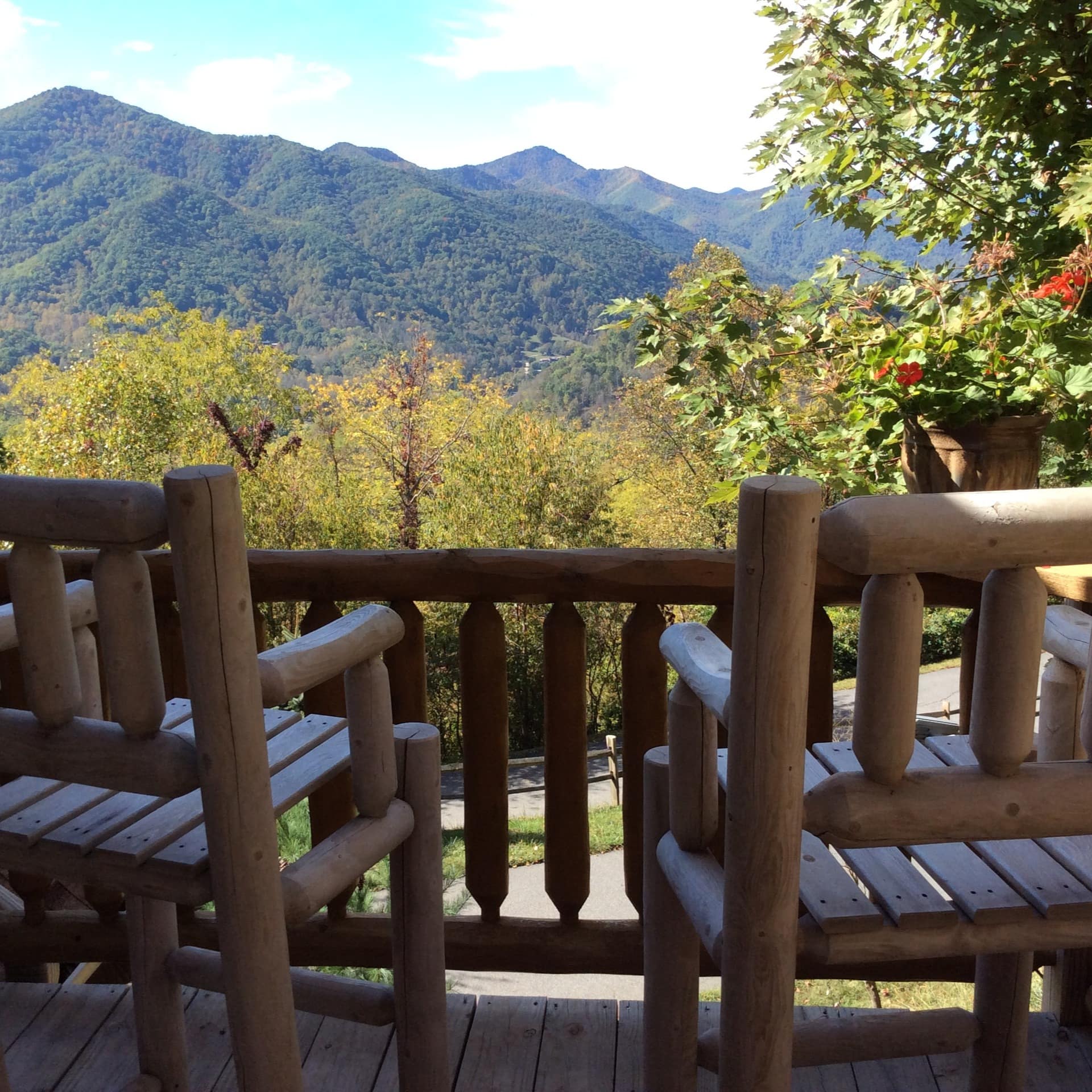 2 chairs on a cabin porch overlooking the mountains