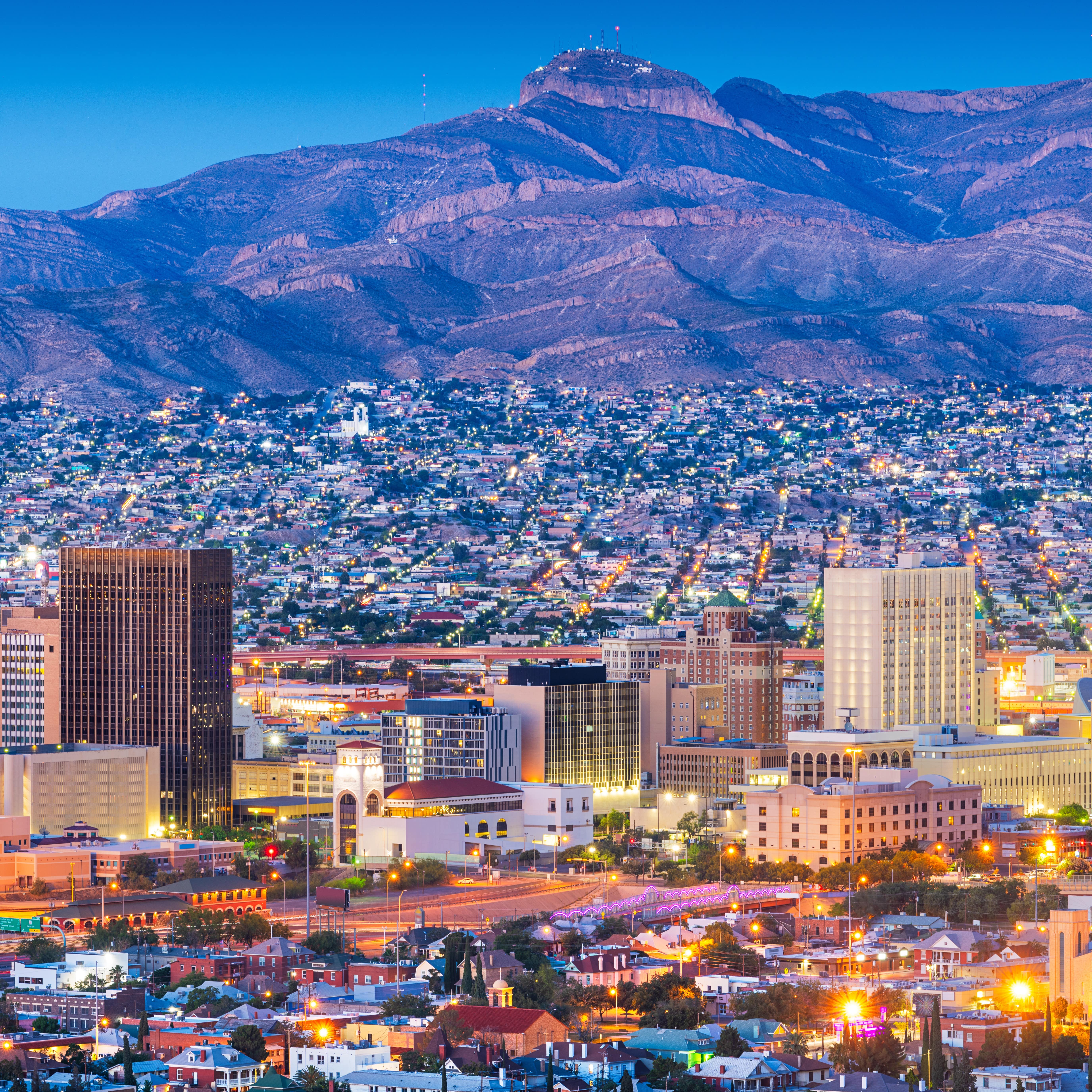 Downtown city skyline at dusk in El Paso with mountains in the background