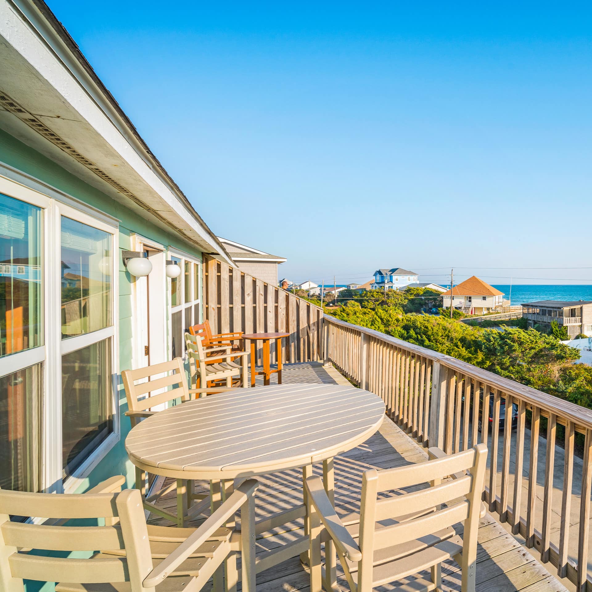 A sunny terrace has seating on it by the ocean in Emerald Isle