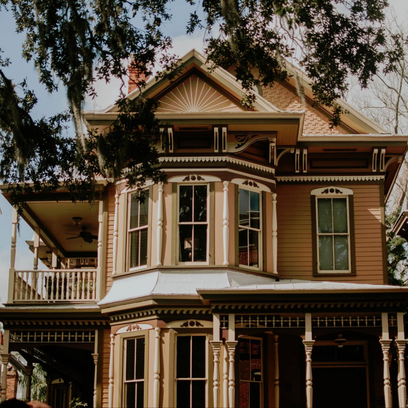 A grand Victorian home with bay windows and pretty porches sits in the historic area of Savannah