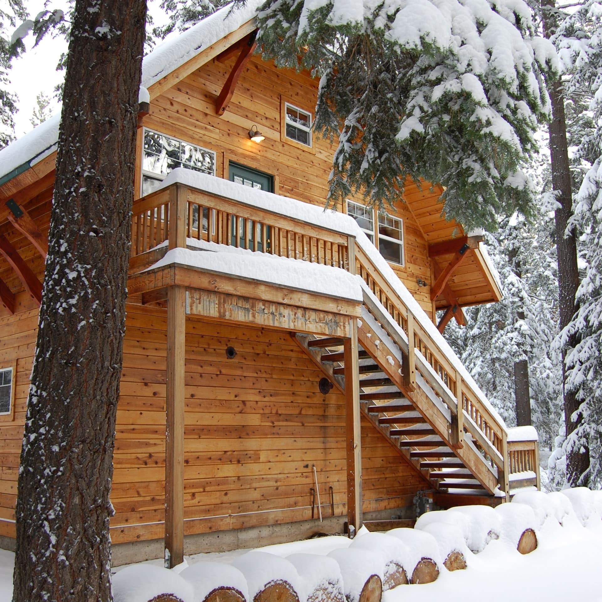 Log cabin with blanket of snow covering roof and surrounding area