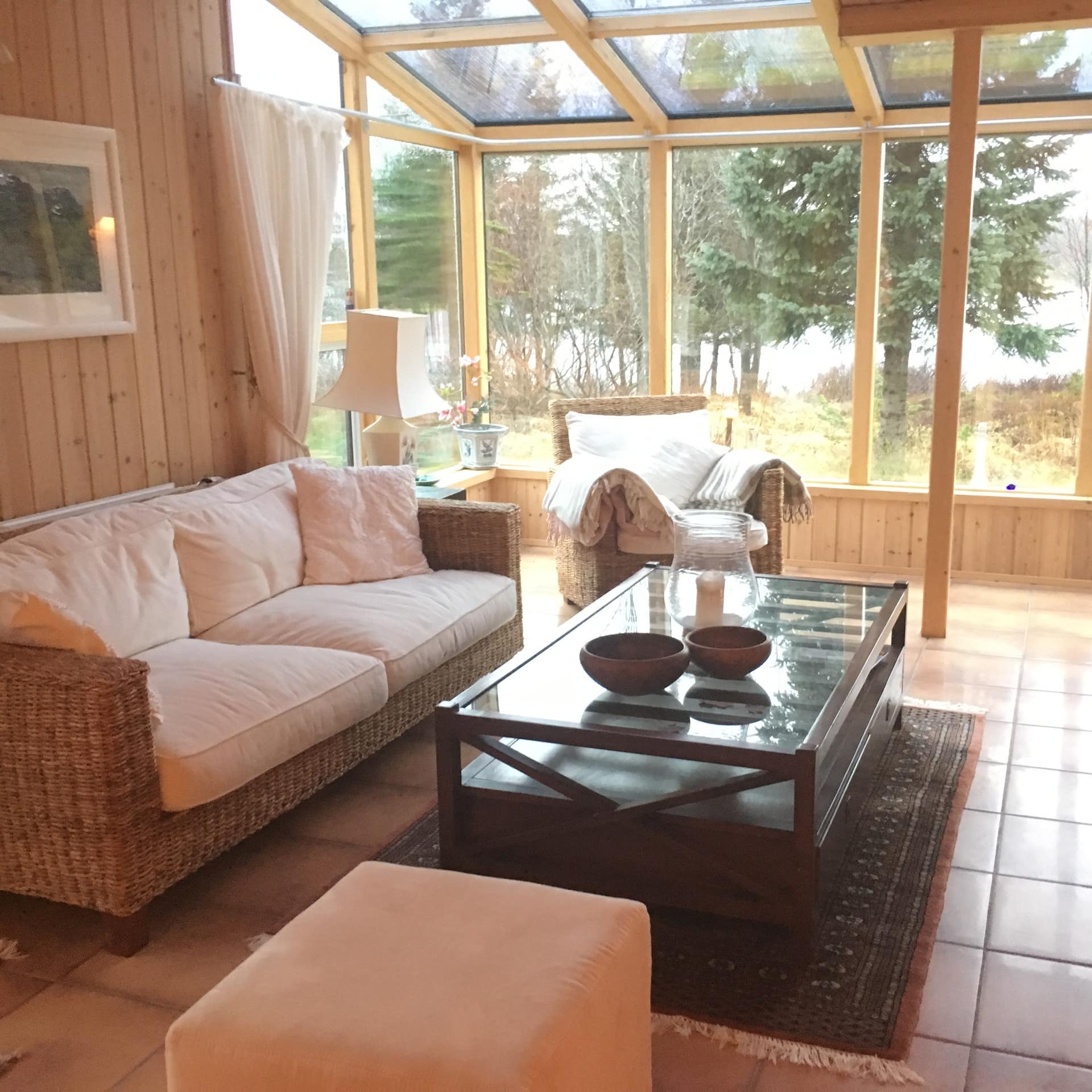 Couches with fluffy cushions in a lounge with large windows