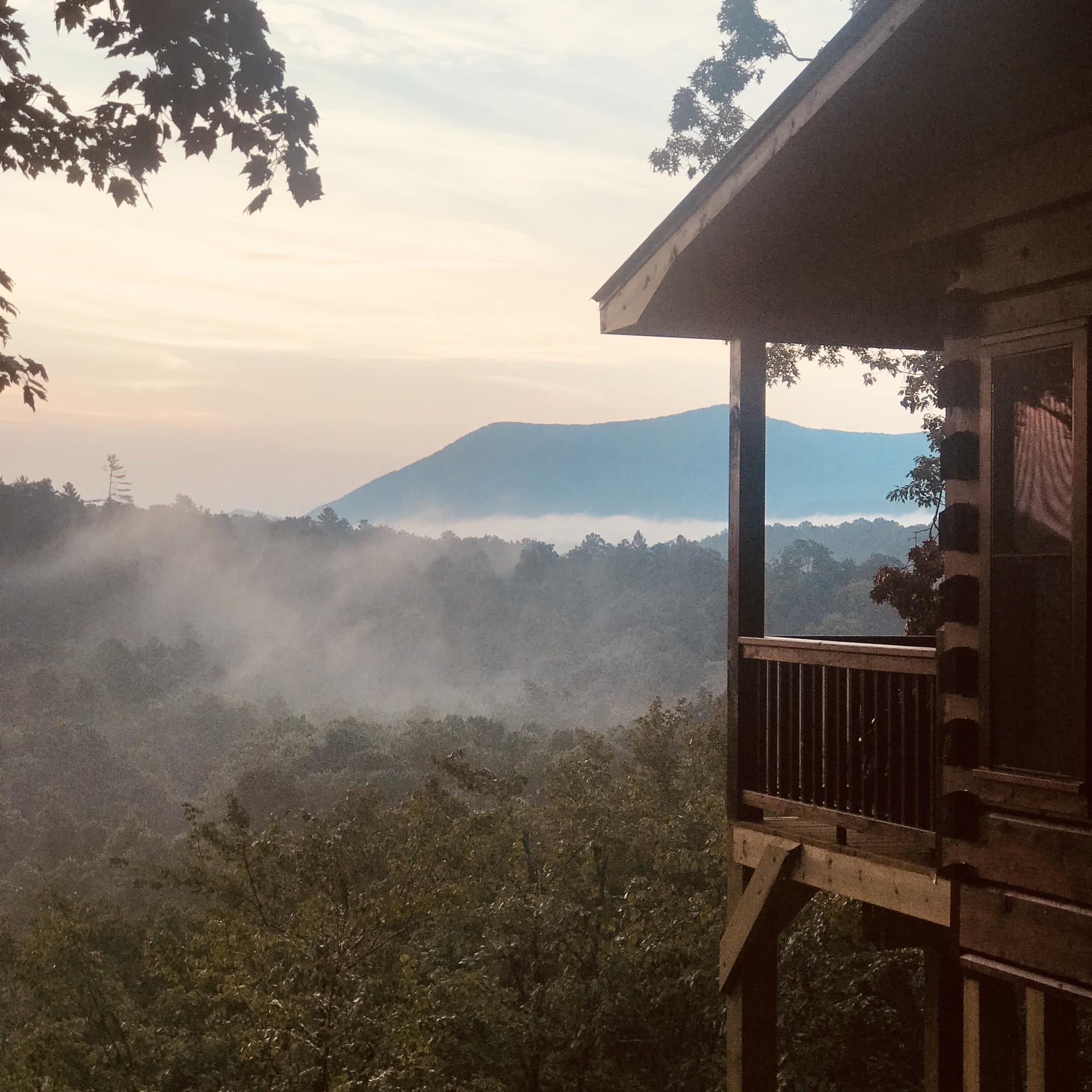 Hillside cabin in the woods with distant mountain view