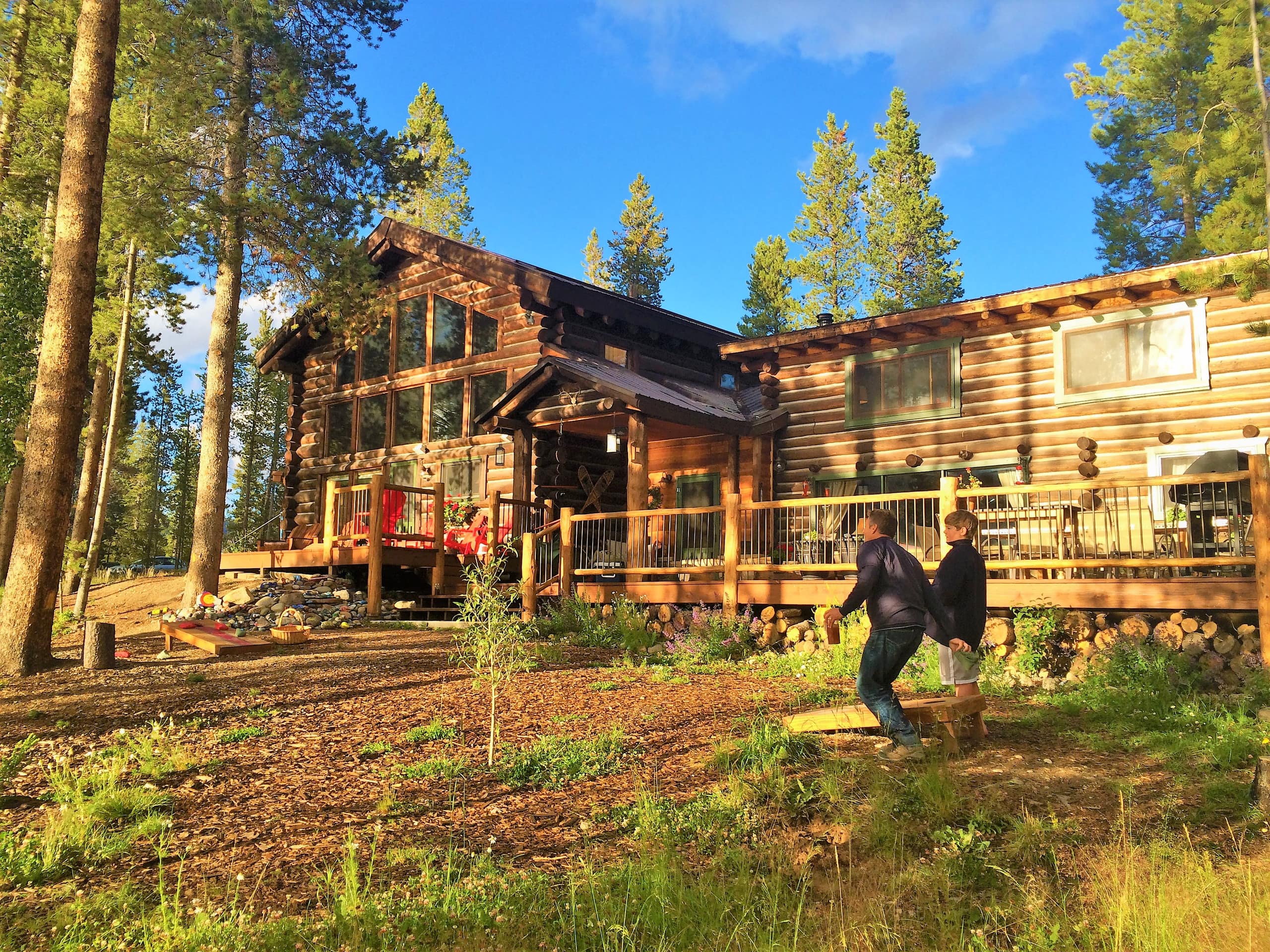 man and boy playing in front of cabin in the woods