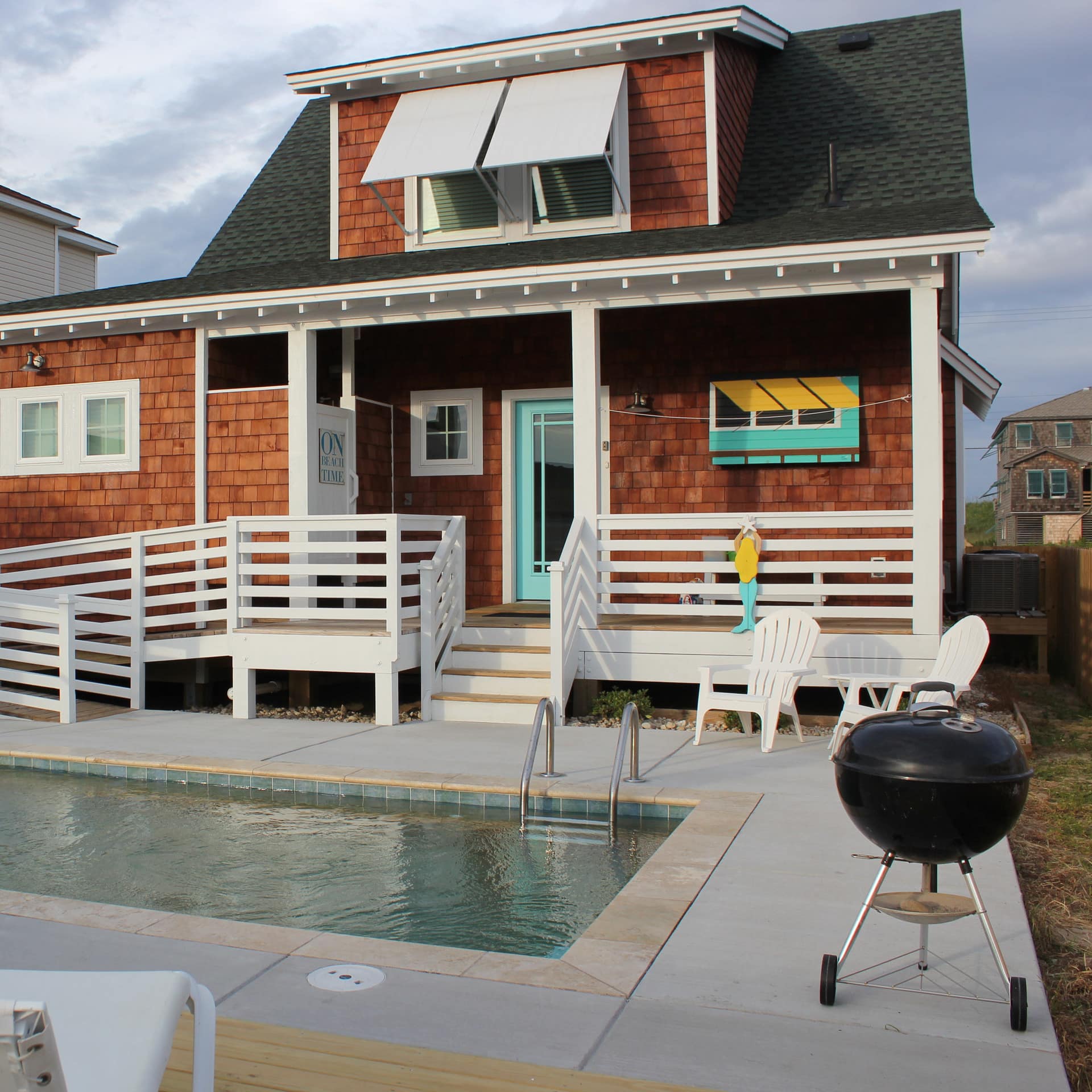 A small cottage with a compact pool and BBQ grill