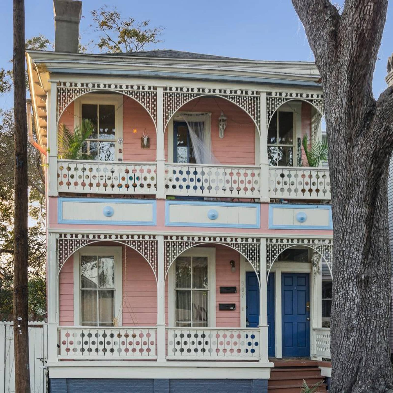 Arched balconies with metal filigrees front pink walls on a charming Savannah house