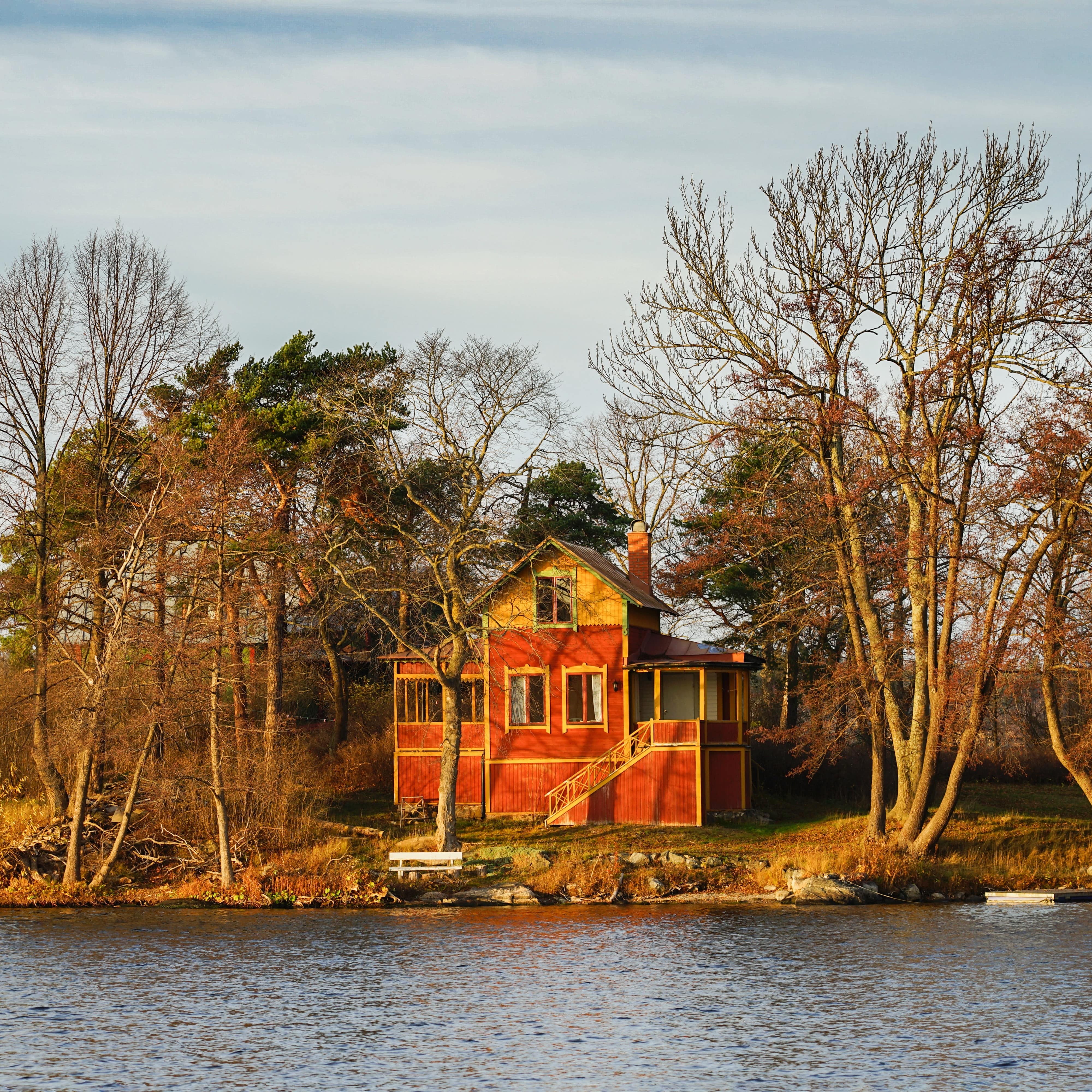 Red painted wooden cabin by a lake