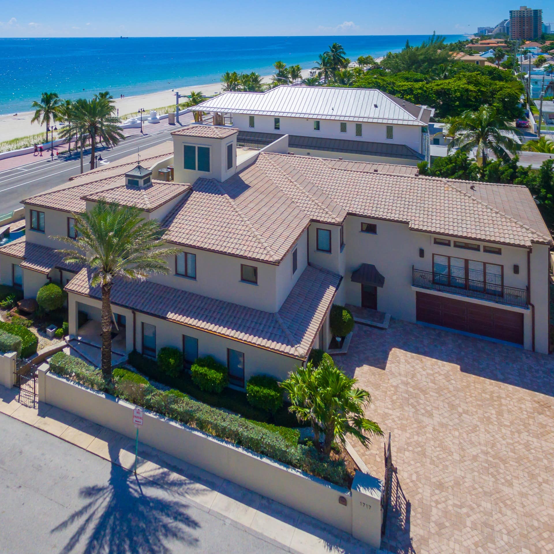 A sprawling beach mansion overlooks an ocean boulevard and the beach