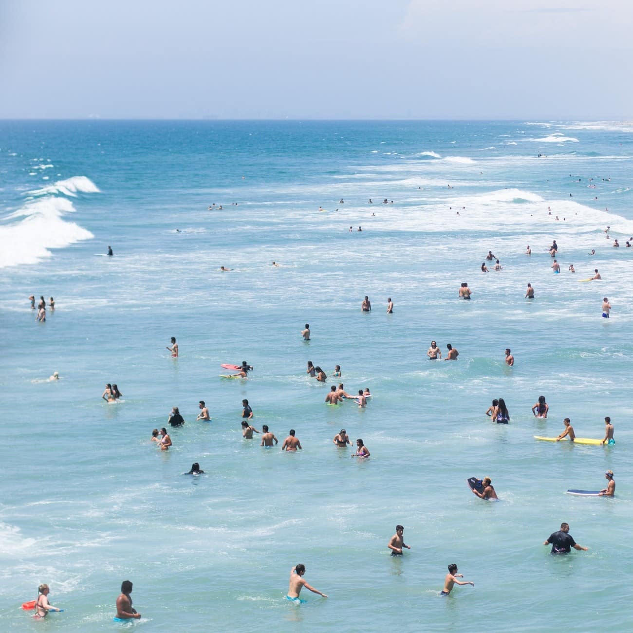 Swimmers and surfers in the waters of Huntington Beach, California