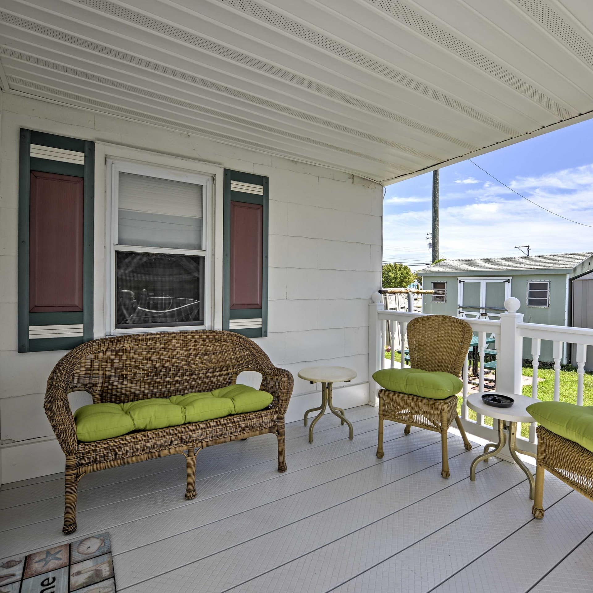 Wicker chairs sit on a breezy porch