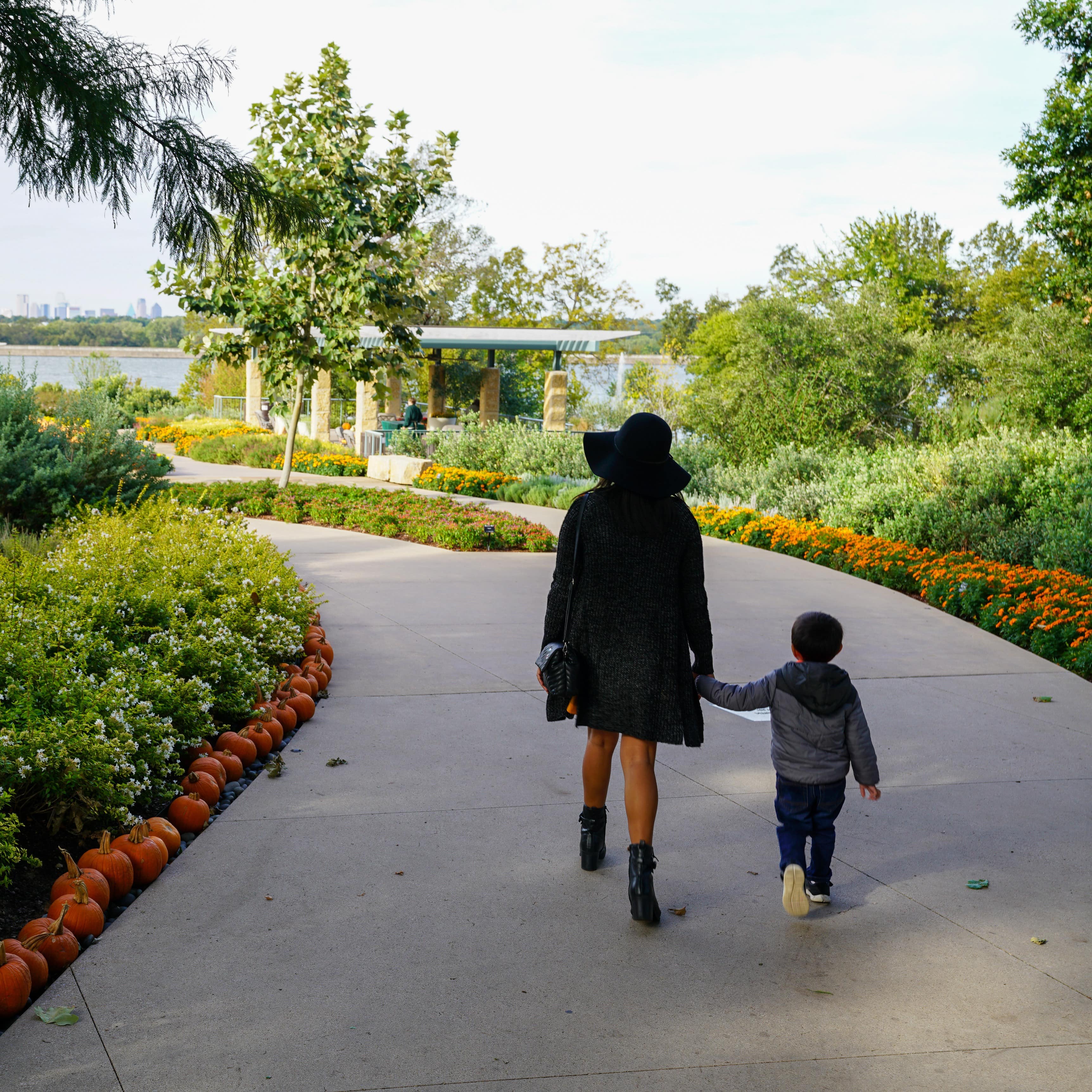 Woman walking holding hands with young boy at a park in Dallas, Texas