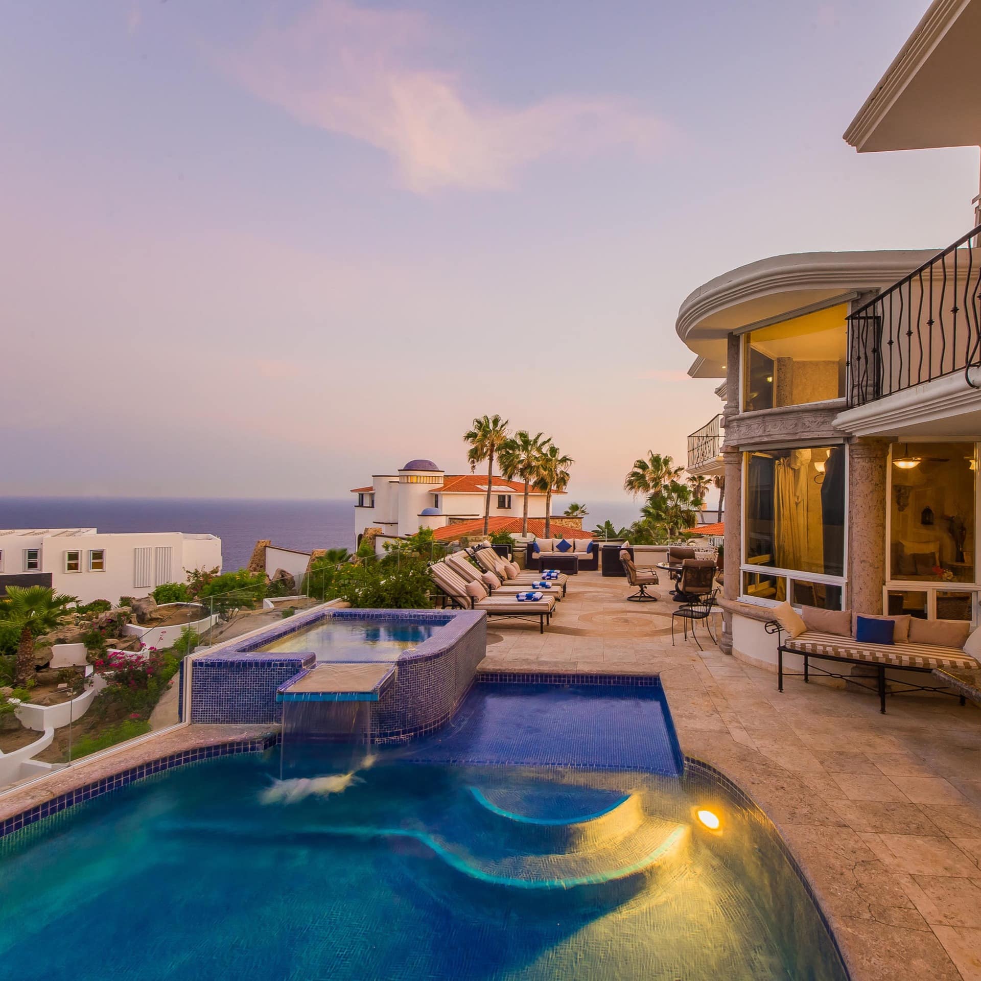 A luxurious villa with a pool and seating area overlooking the ocean in Cabo San Lucas