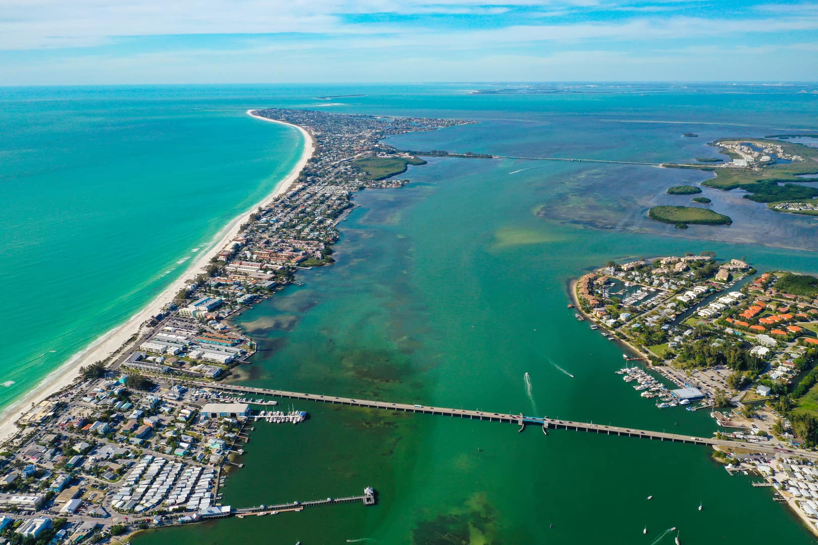 view of Bradenton area and the cortez bridge from above, showing white sand beaches and colorful water