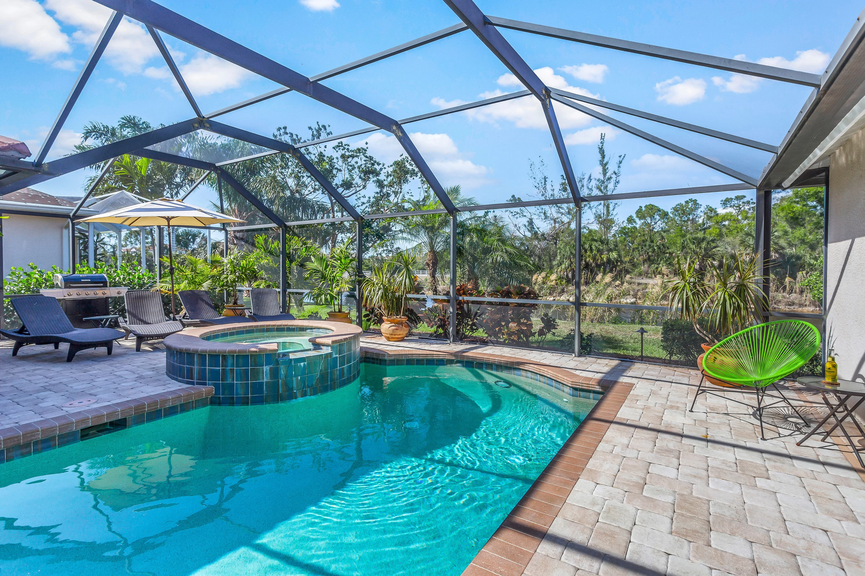 This serene villa has a covered pool and deck area surrounded by lush tropical foliage.