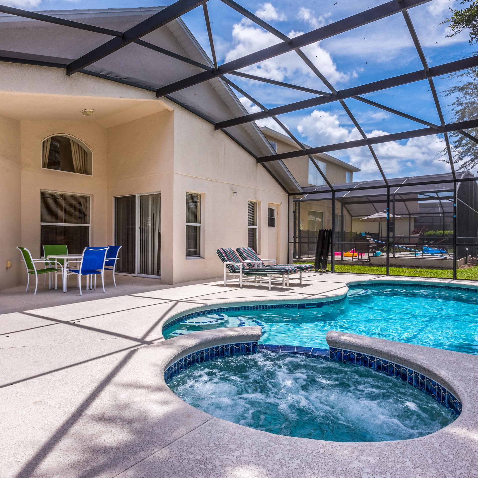 A villa with a pool, jacuzzi, and seating area in an extended patio near Disney