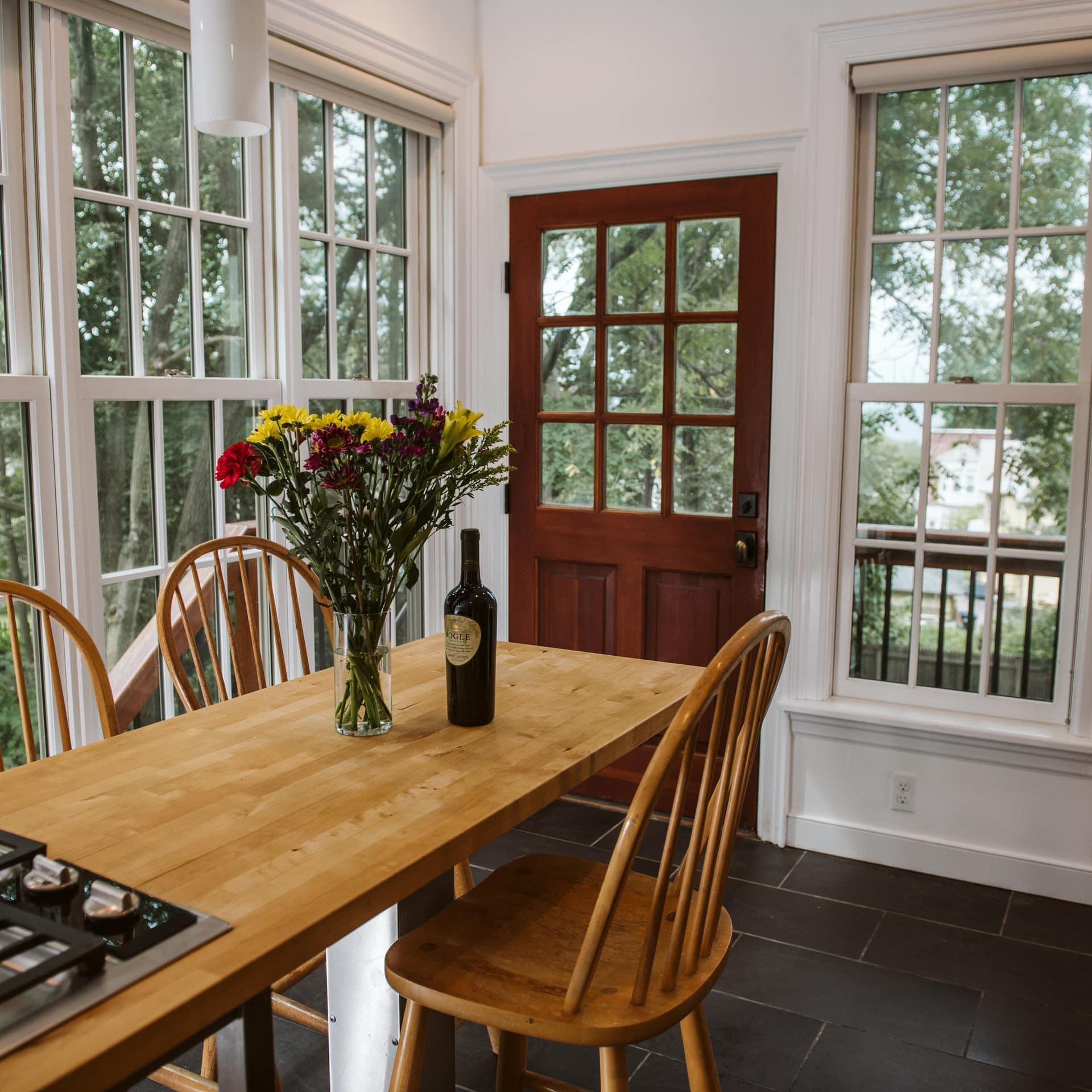 A bright dining room with large windows and table in a B&B in Burlington