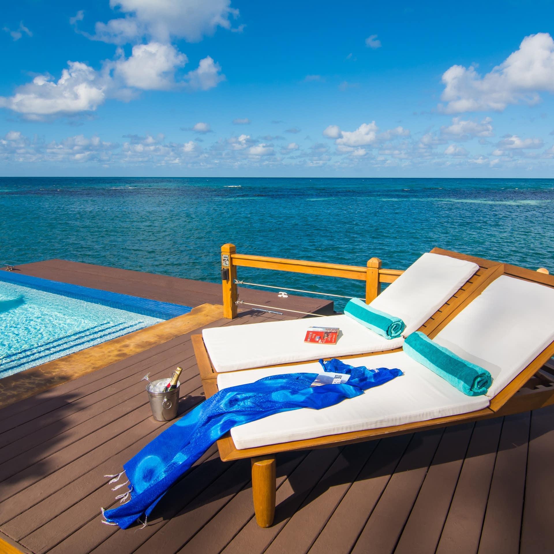 A luxury over-water villa deck with sunbeds and pool in Jamaica
