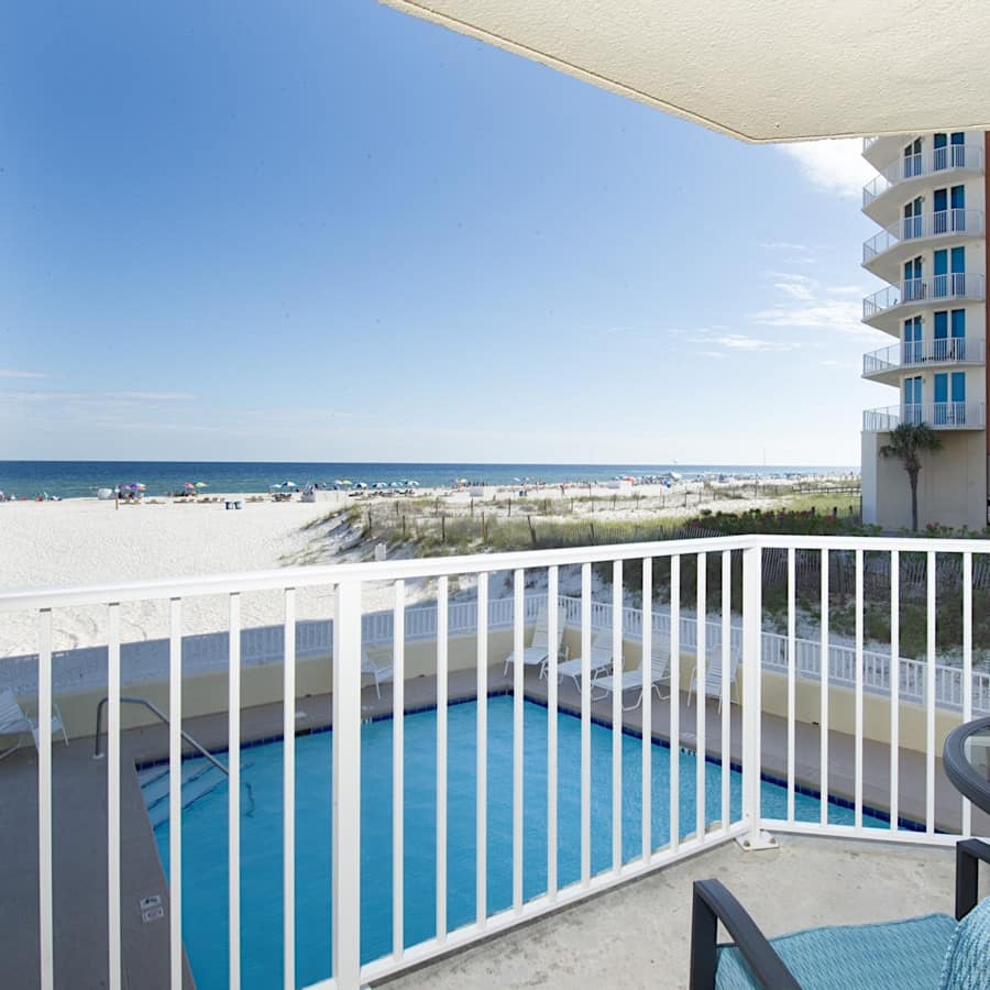 The view from the balcony of a condo with a pool right by the white sands of Gulf Shores