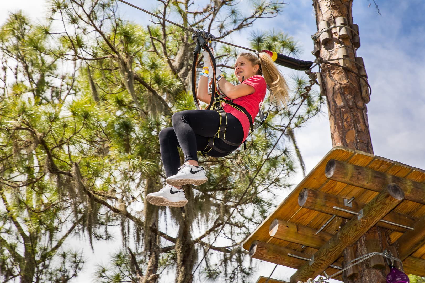 girl in a pink shirt on a zipline at TreeUMPH