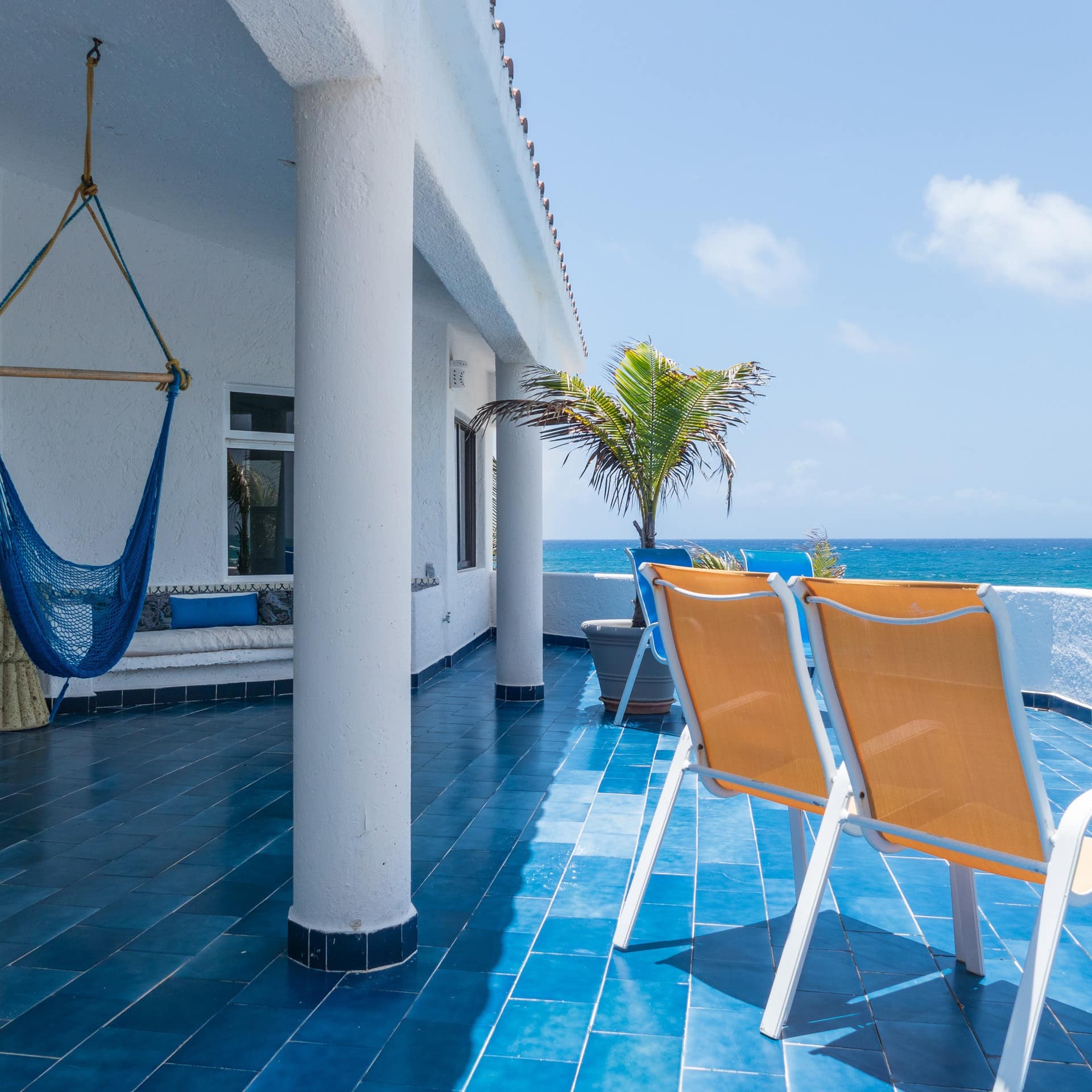 An over-water villa with a large terrace and seating area overlooking the Caribbean Sea