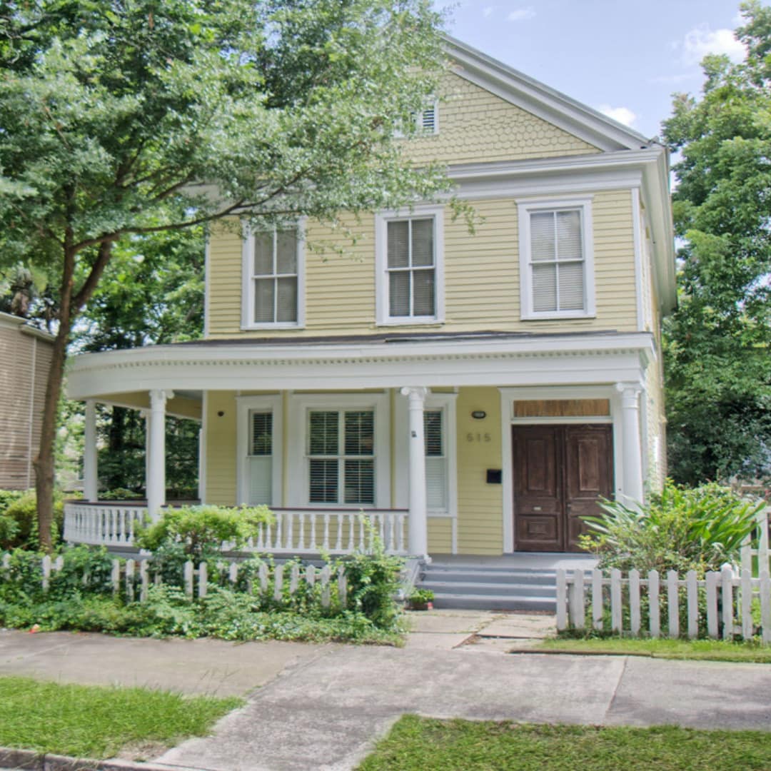 A wood-paneled cottage sits on the sidewalk of Savannah, GA