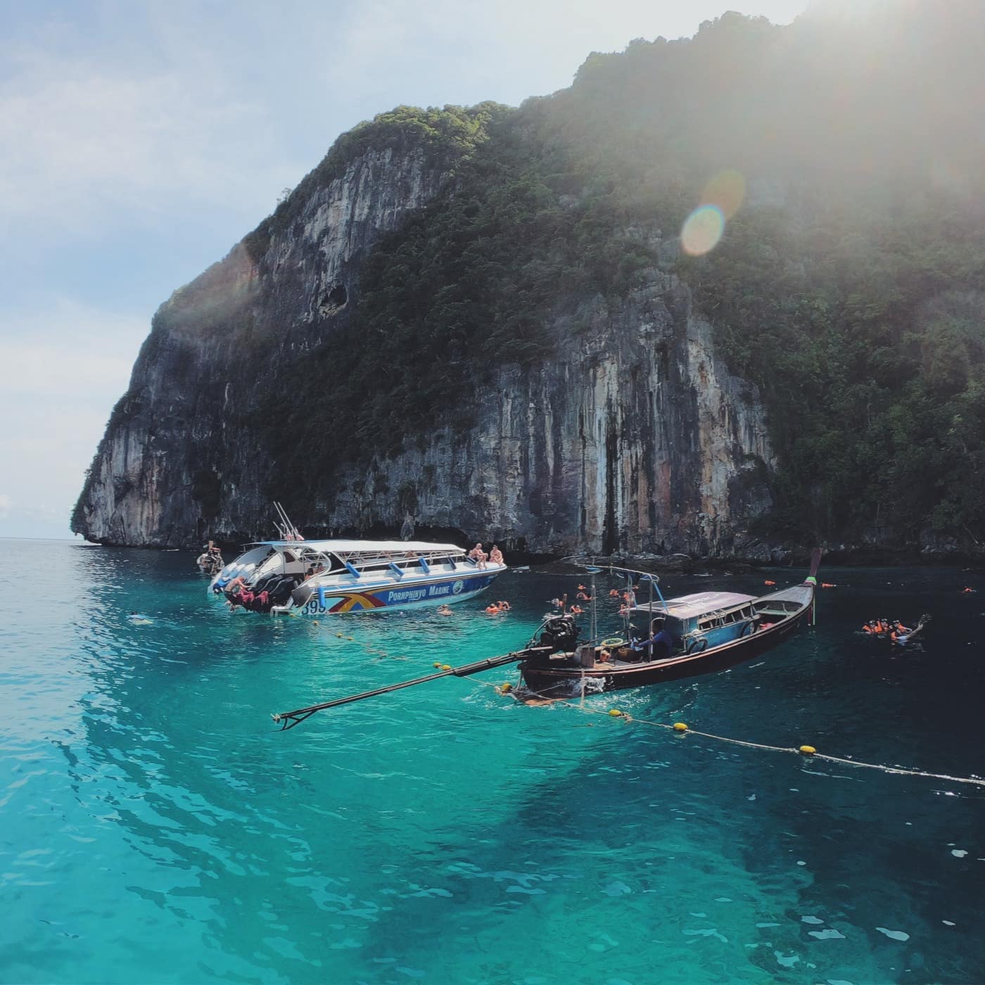 Boats are moored in blue waters by the Phi Phi Islands in Thailand