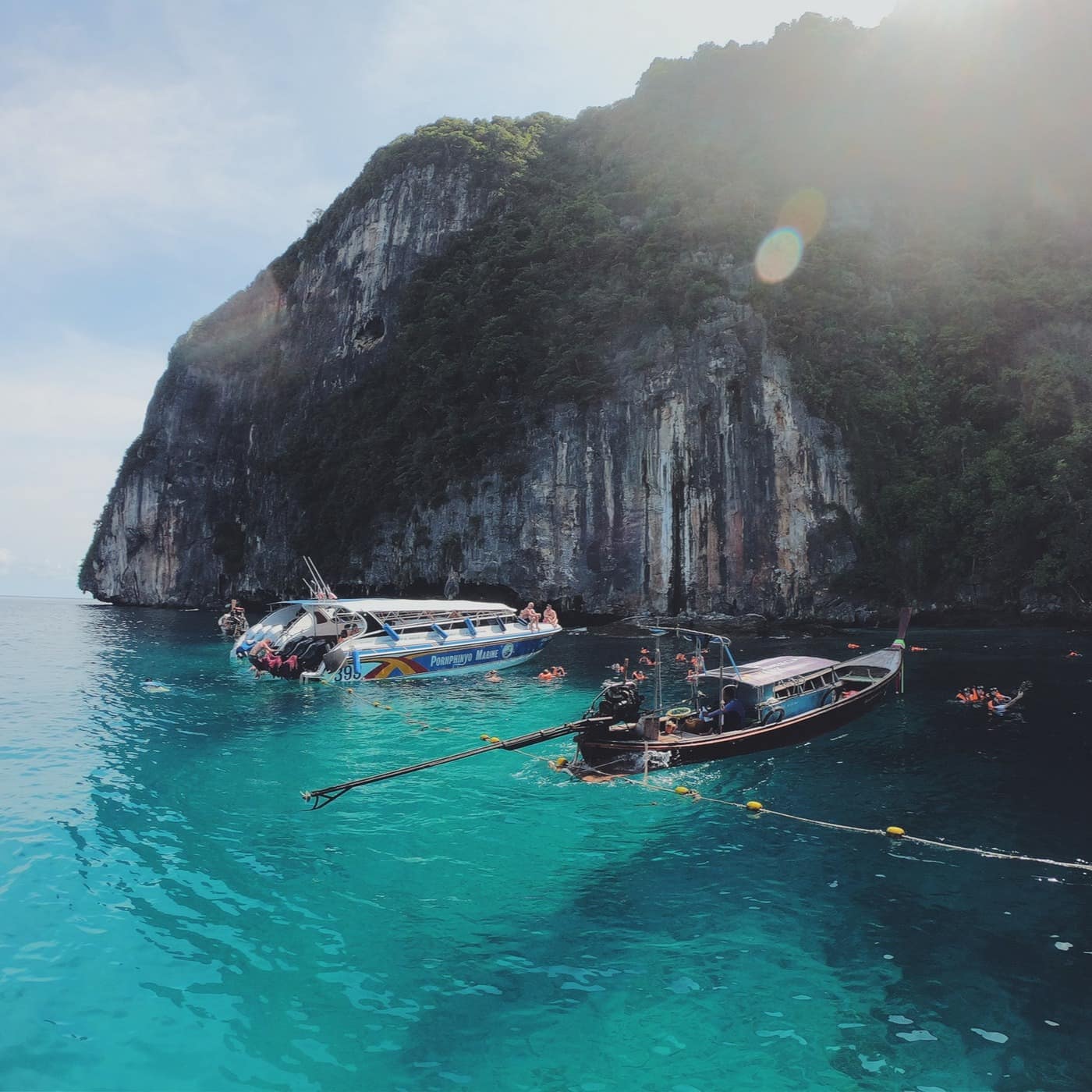Boats are moored in blue waters by the Phi Phi Islands in Thailand
