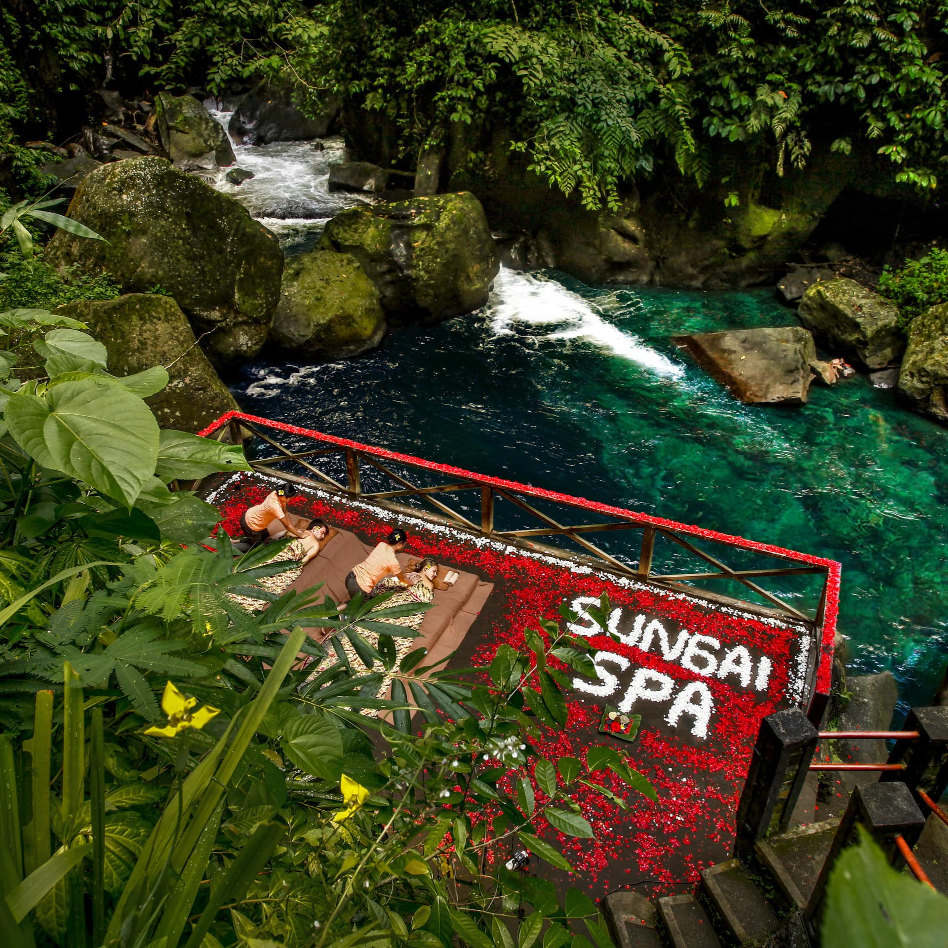 Couple enjoying a massage on an outdoor deck built over a river