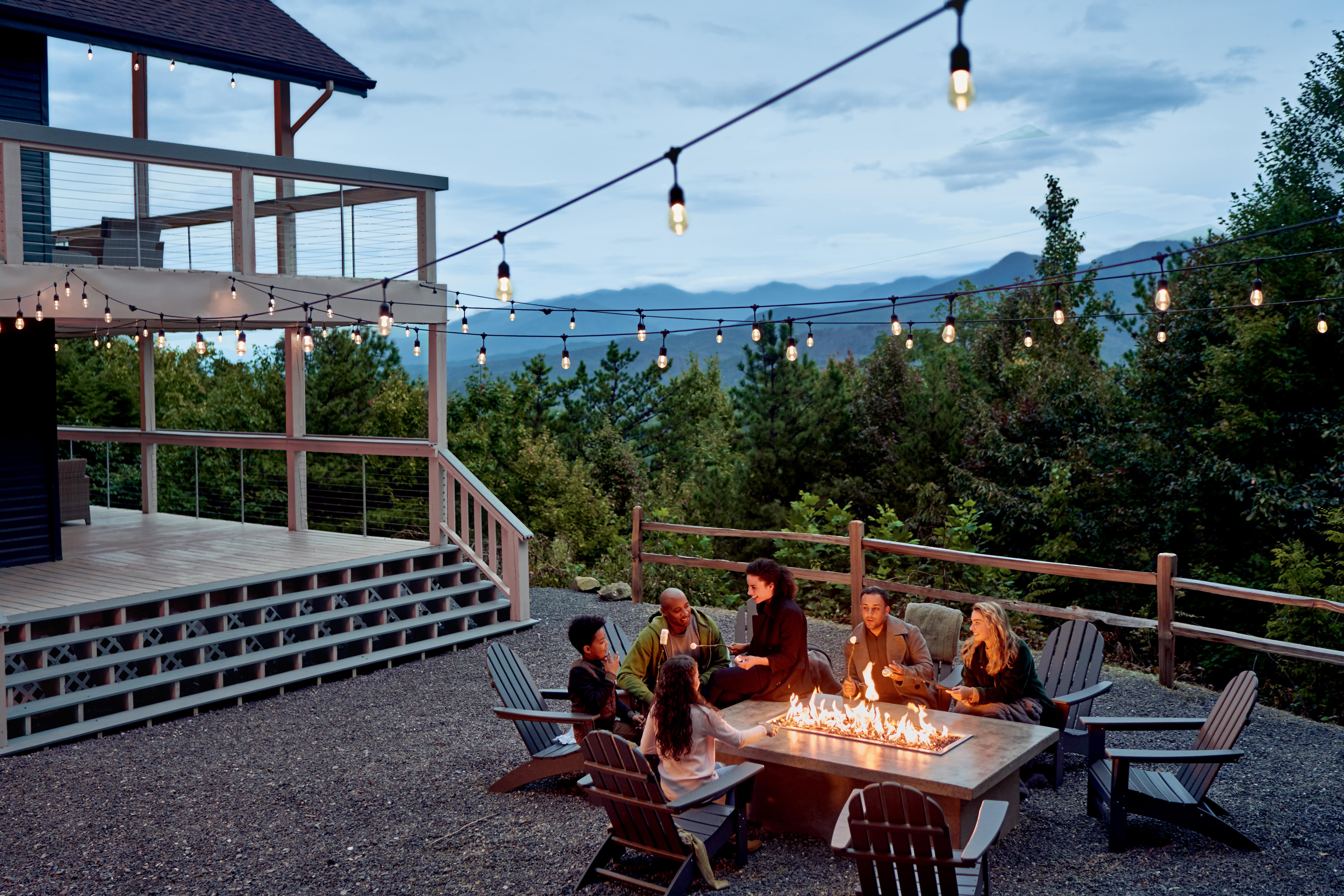 Family gathered around a firepit making s’mores.