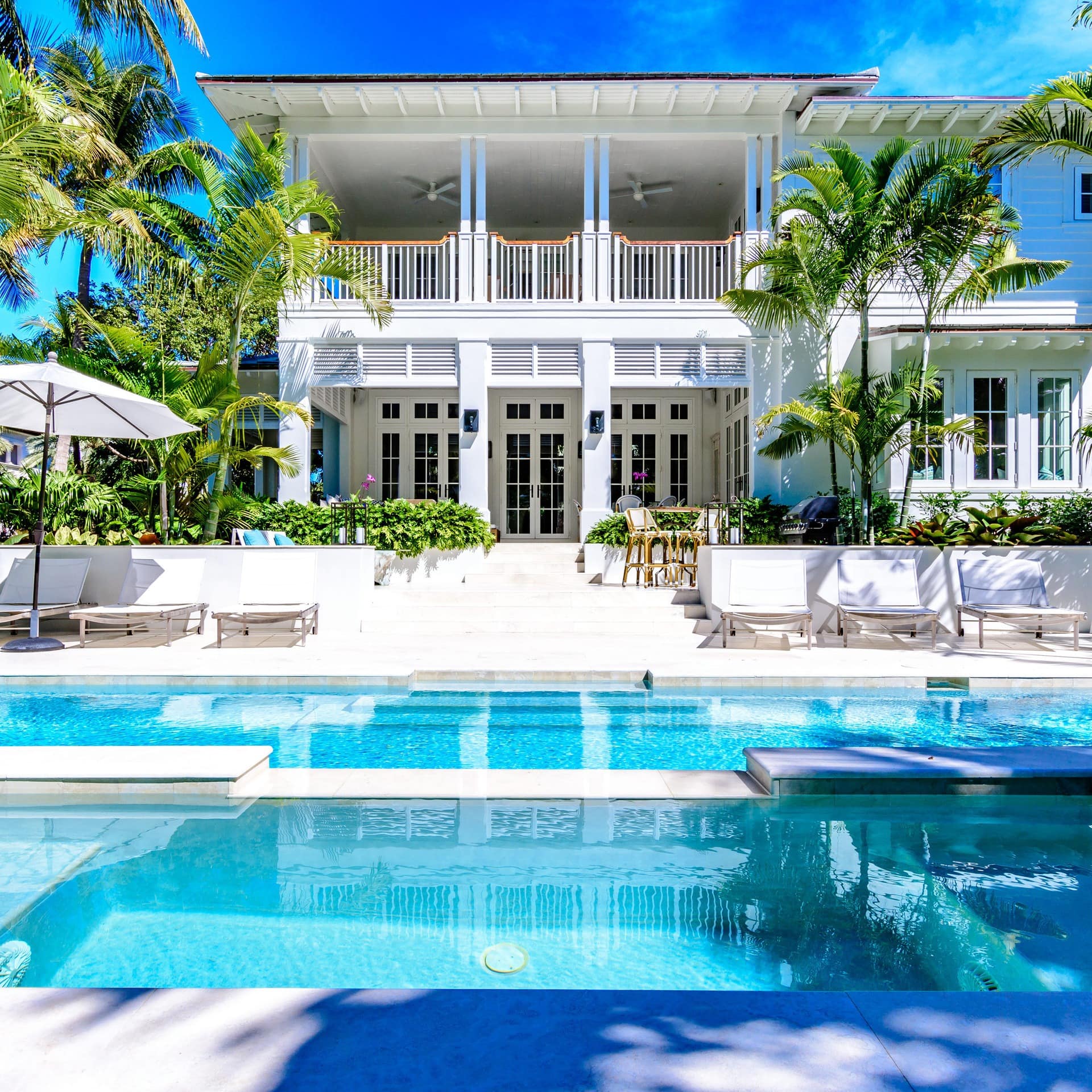 A stunning whitewashed Miami mansion with two pools and palm trees