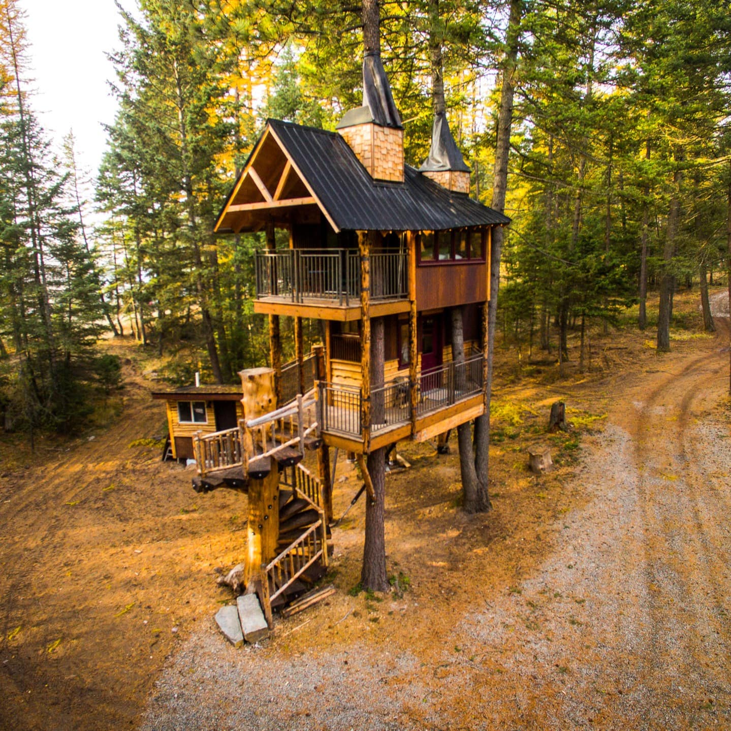 A tall treehouse vacation letting in Montana has several floors and decks overlooking the pine forest