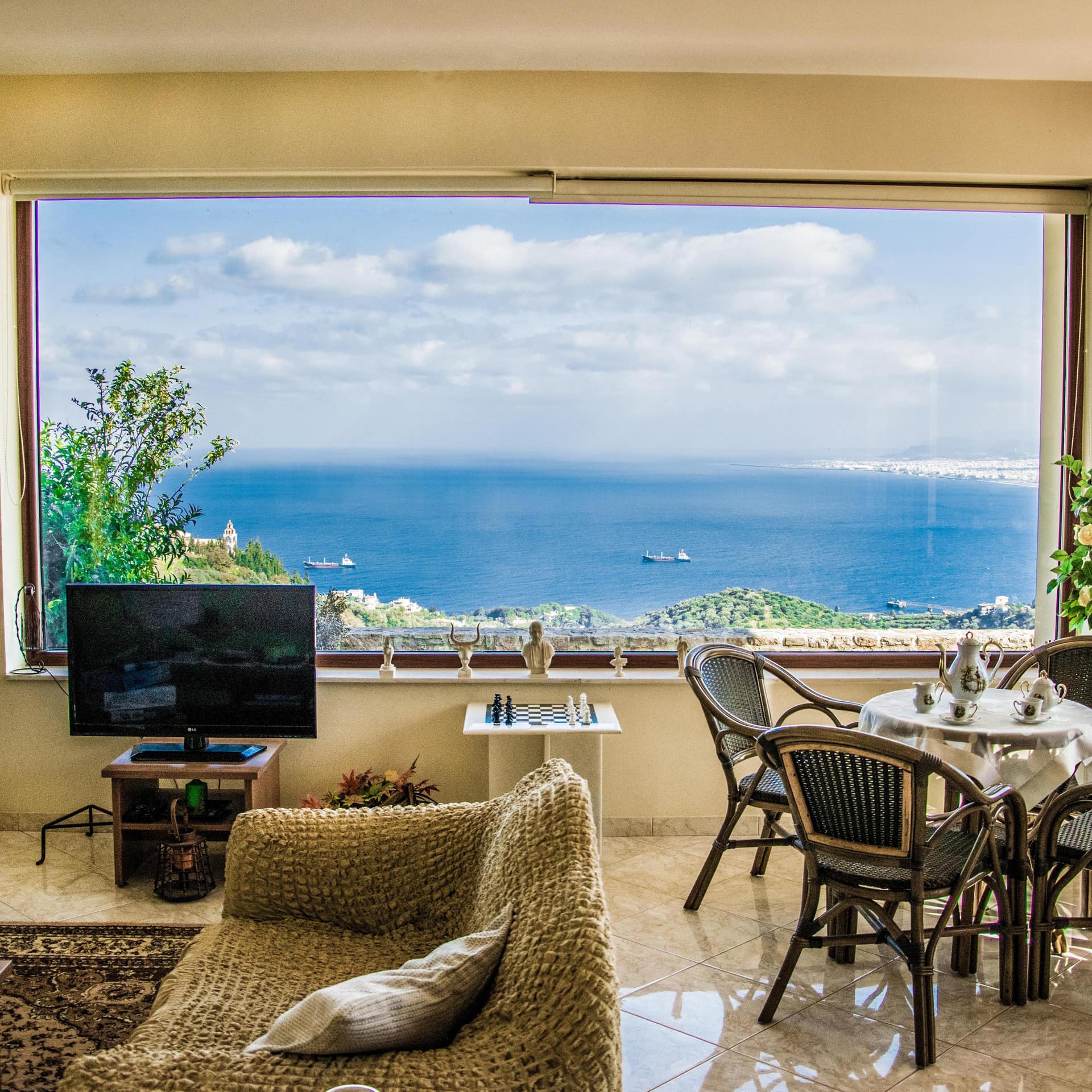 Living room interior with a picture window overlooking the sea.
