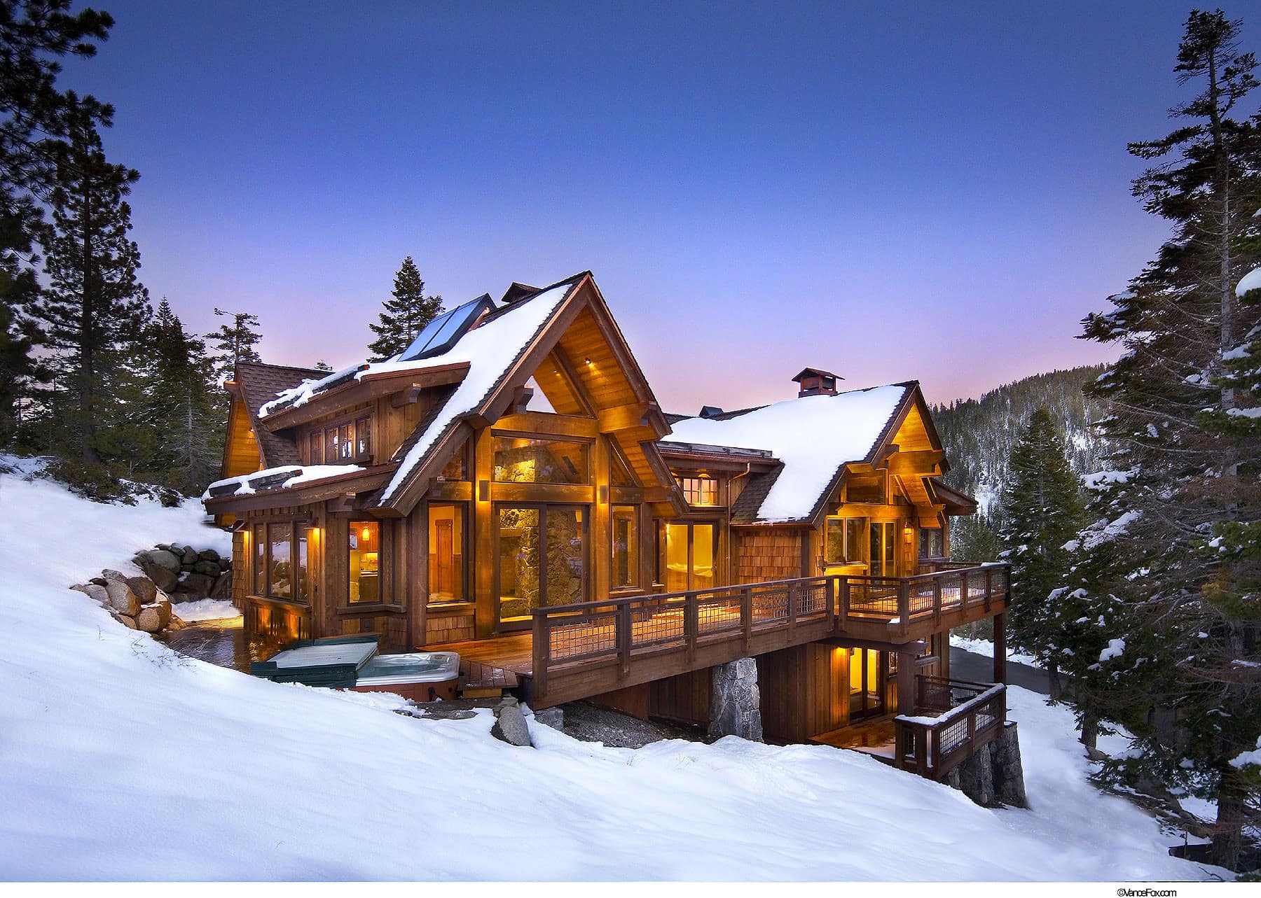 cabin in the woods with snow and mountains at dusk