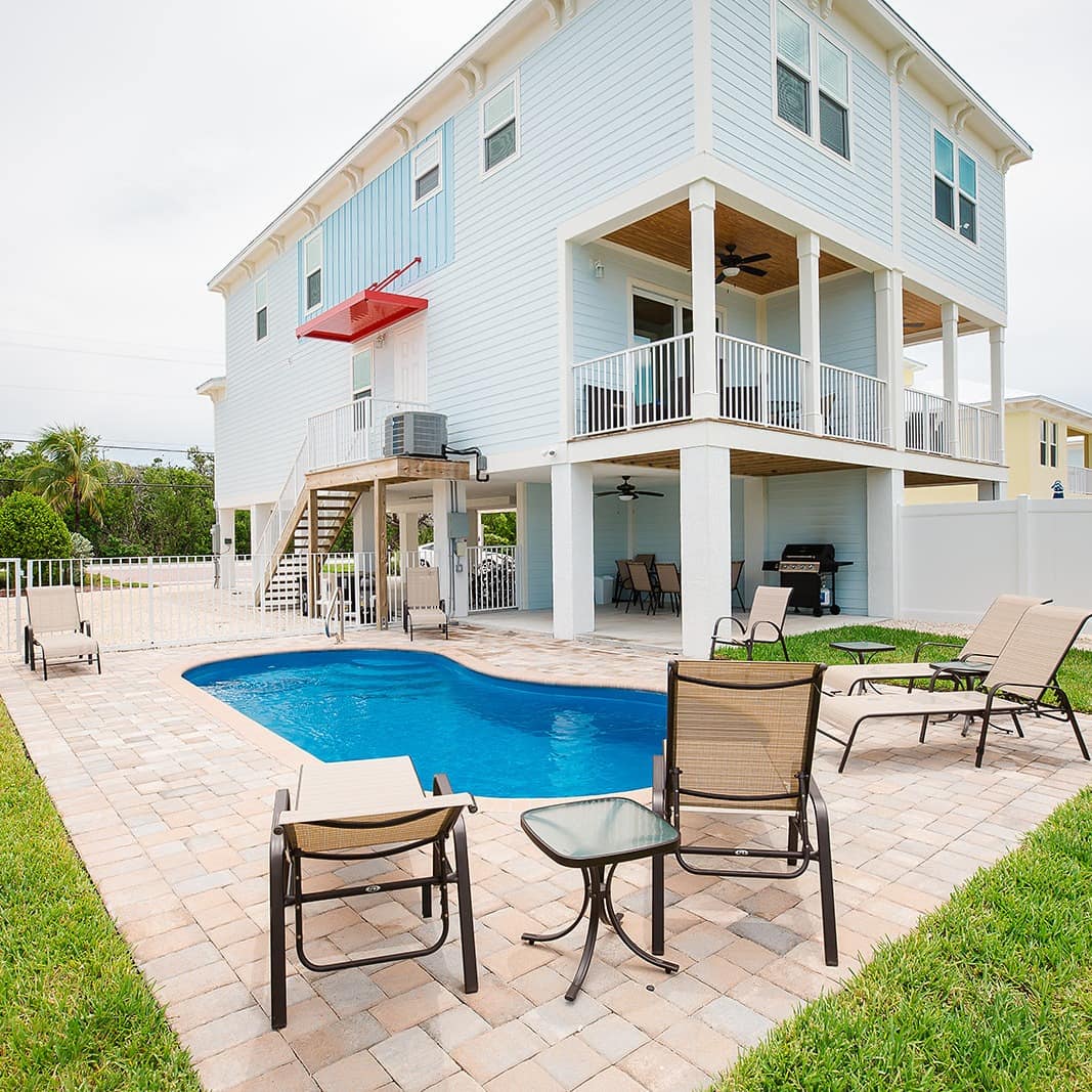 A family villa in Florida with a private garden that has a swimming pool and sunbeds