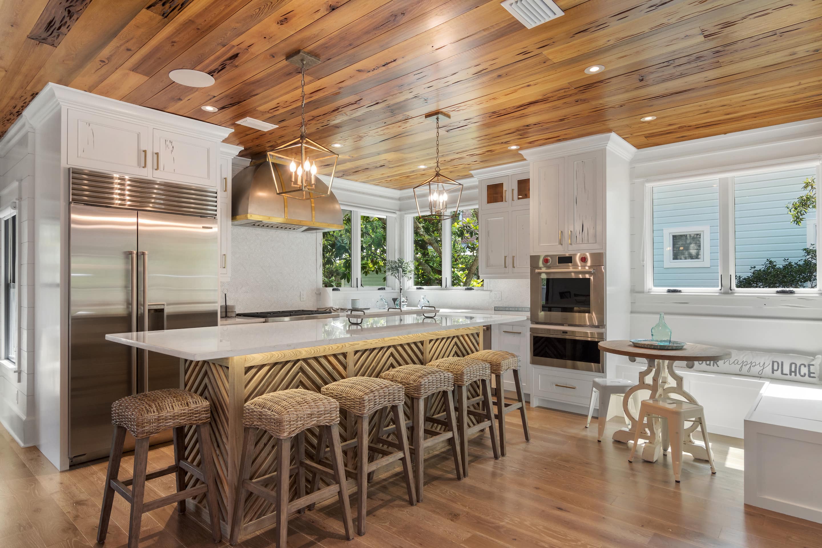 This is a kitchen with a hardwood ceiling and uniquely patterned island.