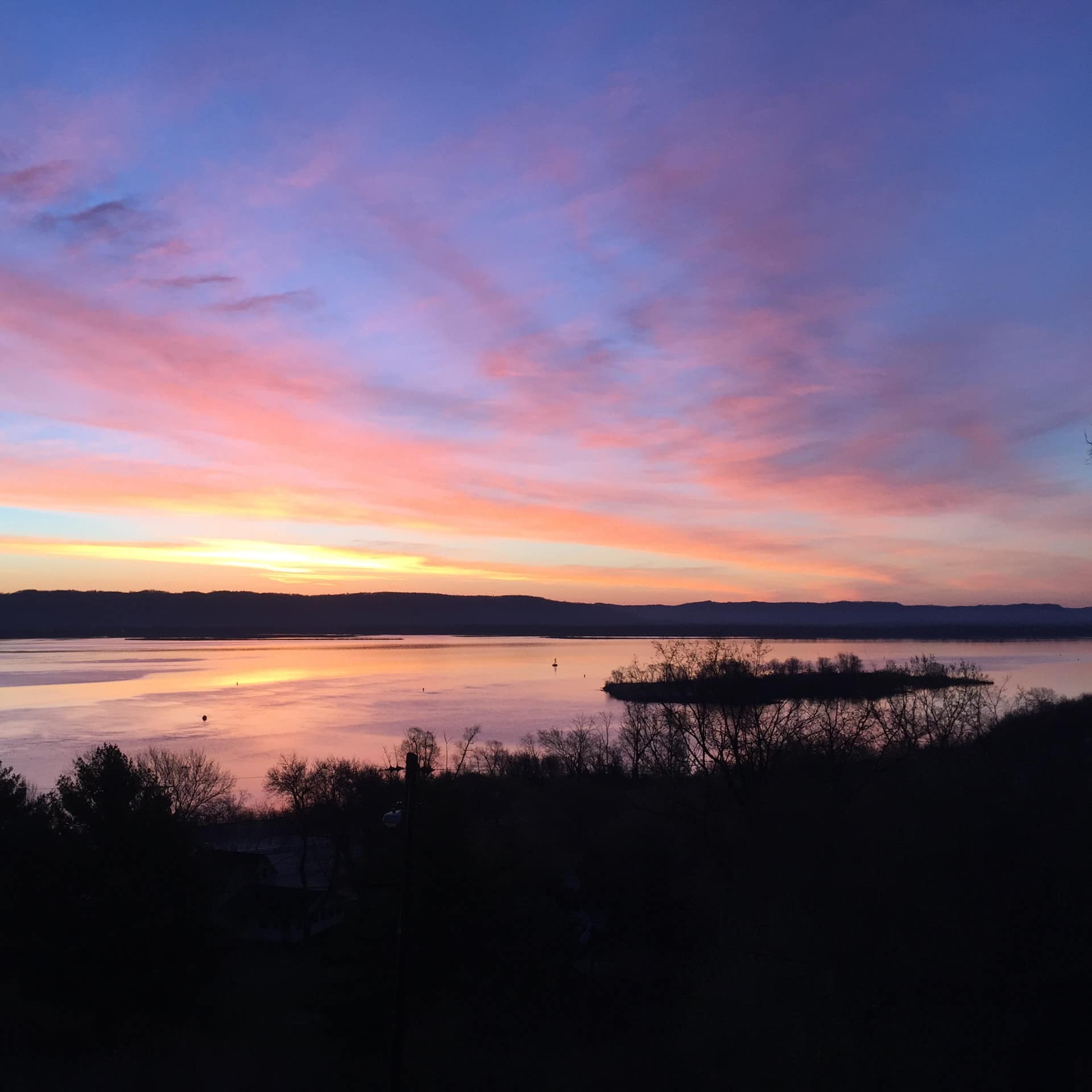 The sunset casts a colorful glow across the Mississippi River