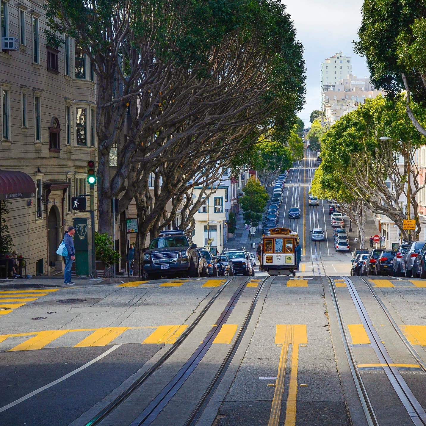 A San Francisco cable car going down a street flanked by buildings