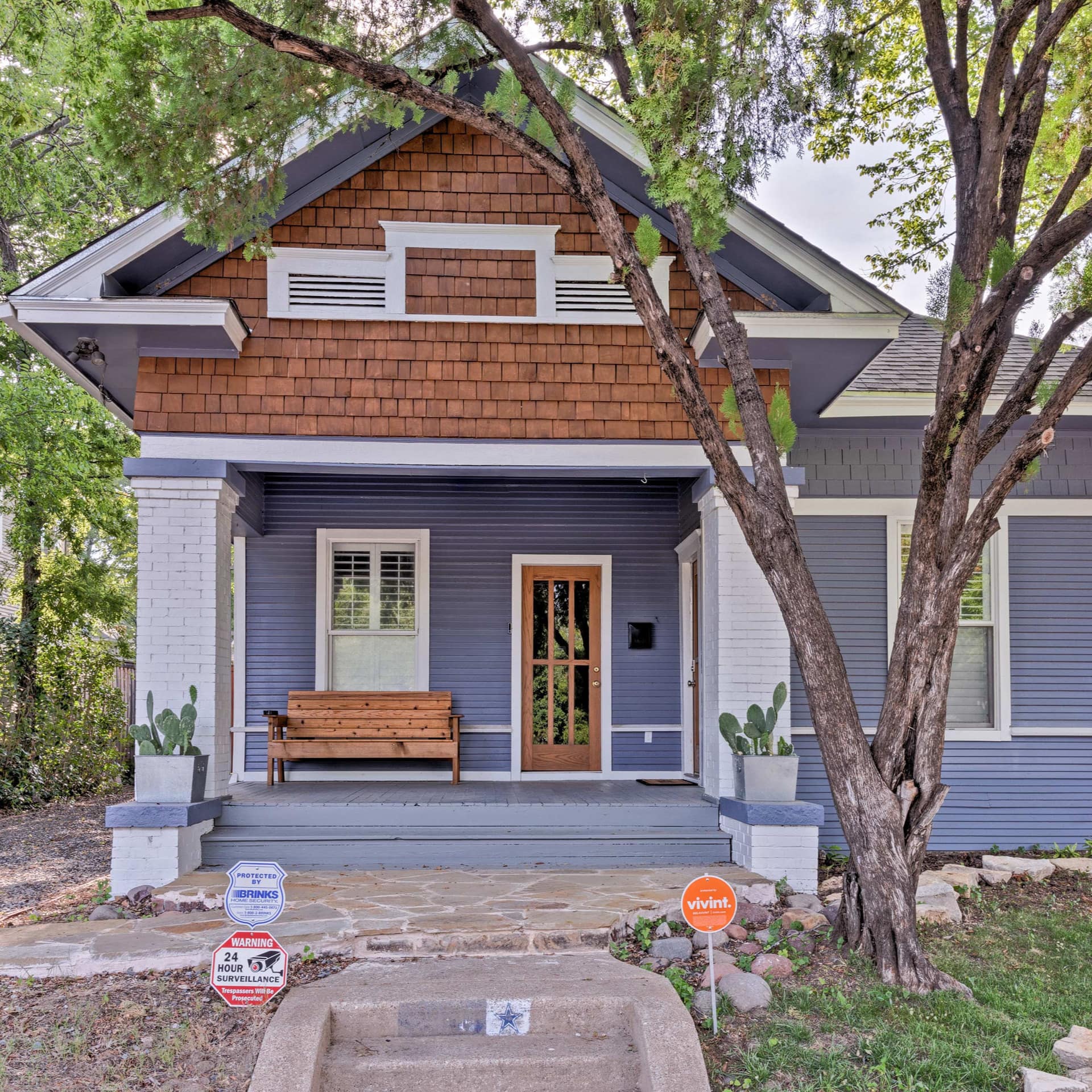 A quaint Craftsman bungalow shaded by the surrounding trees