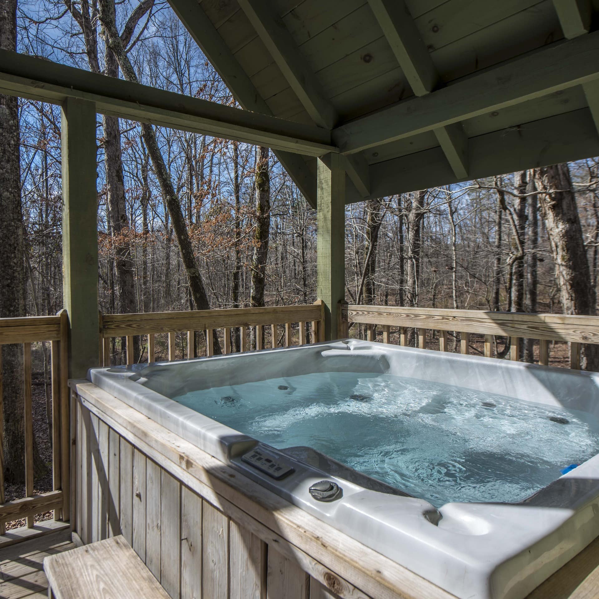 Hot tub on a cabin deck in the woods