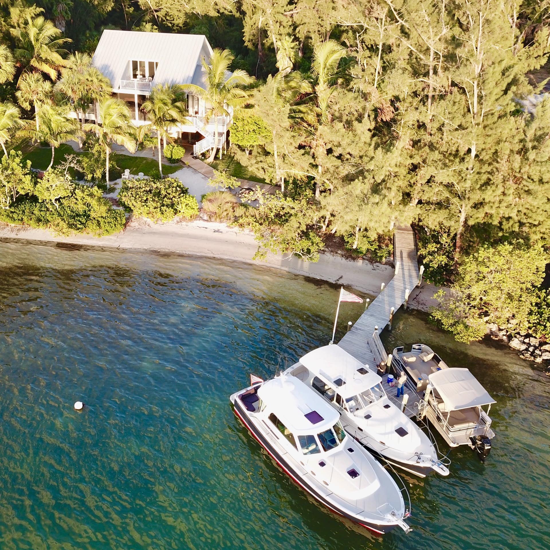 An aerial view of a pet-friendly luxury vacation home with its own private beach and dock