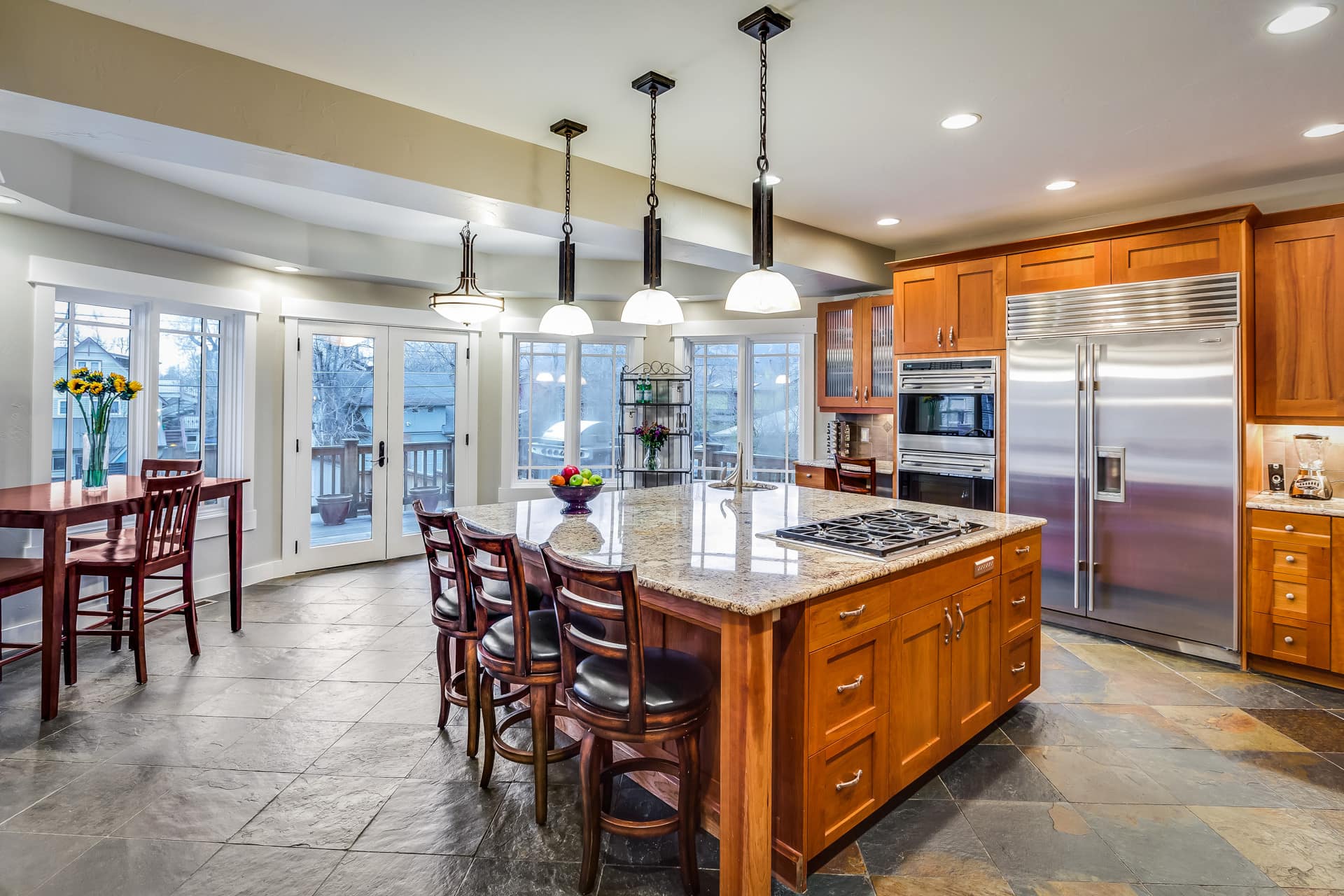 This is a kitchen with a large, square-shaped island and built-in refrigerator.