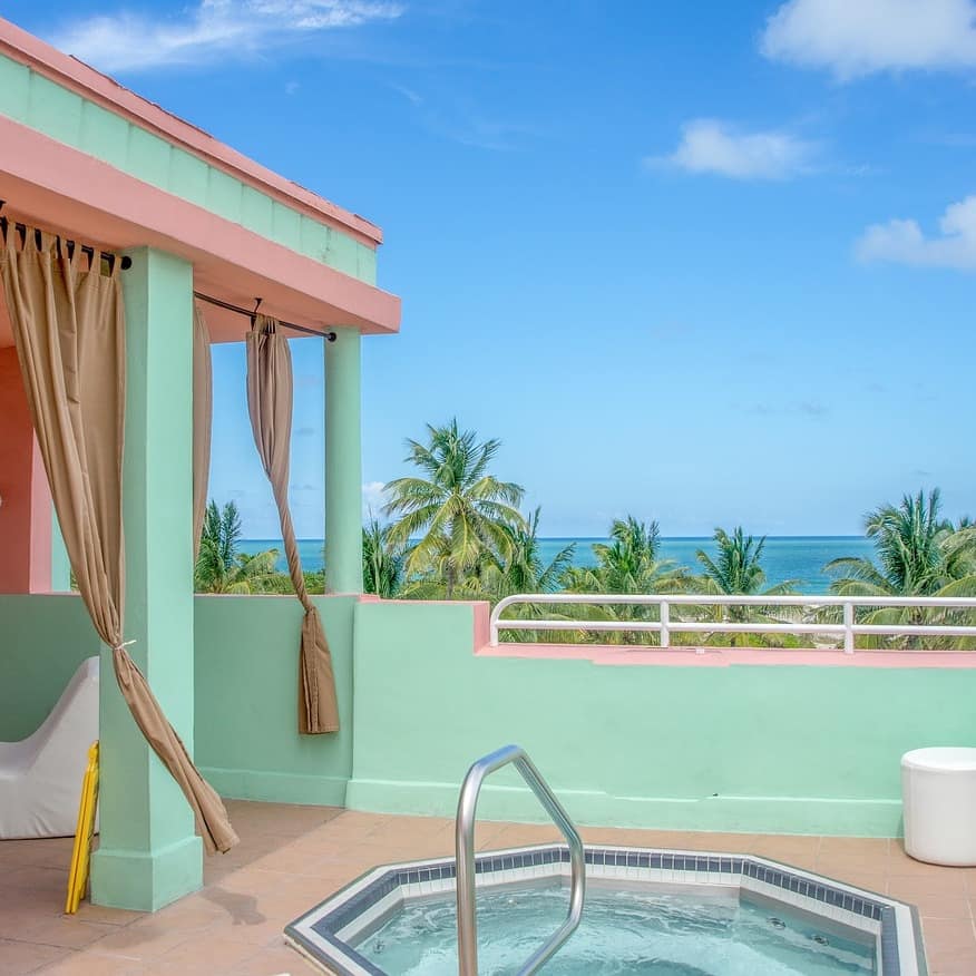 A colorful Florida beach house with a hot tub near some seaside palms