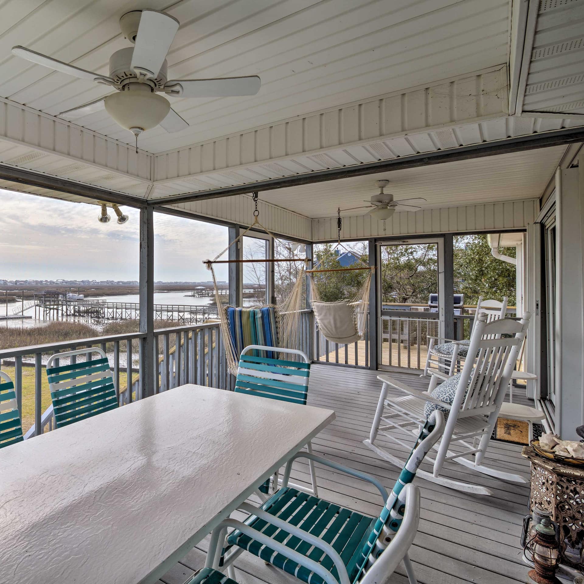 Porch with hammocks overlooking a dock and inlet