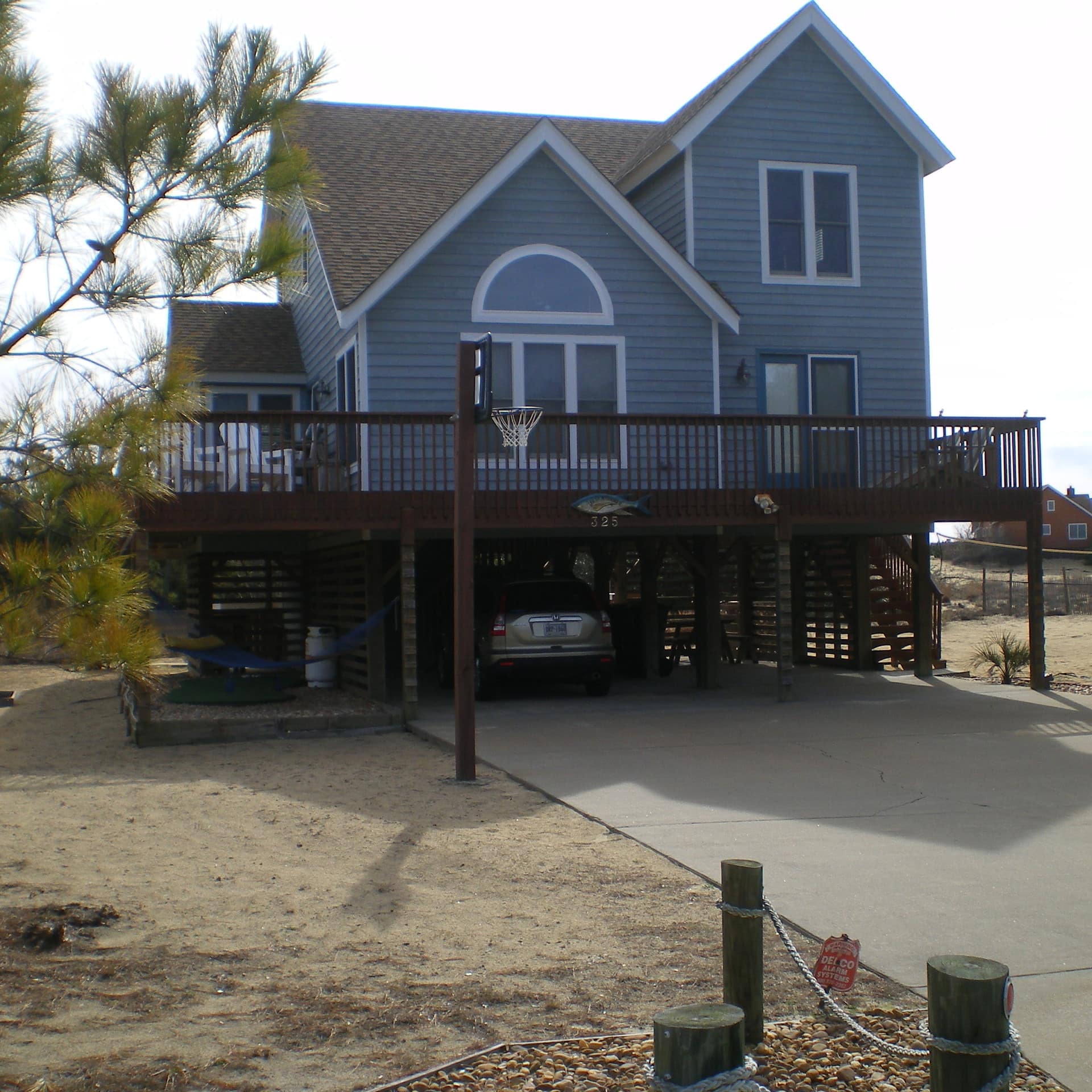 A blue-tinted house is just meters away from the rolling ocean waves