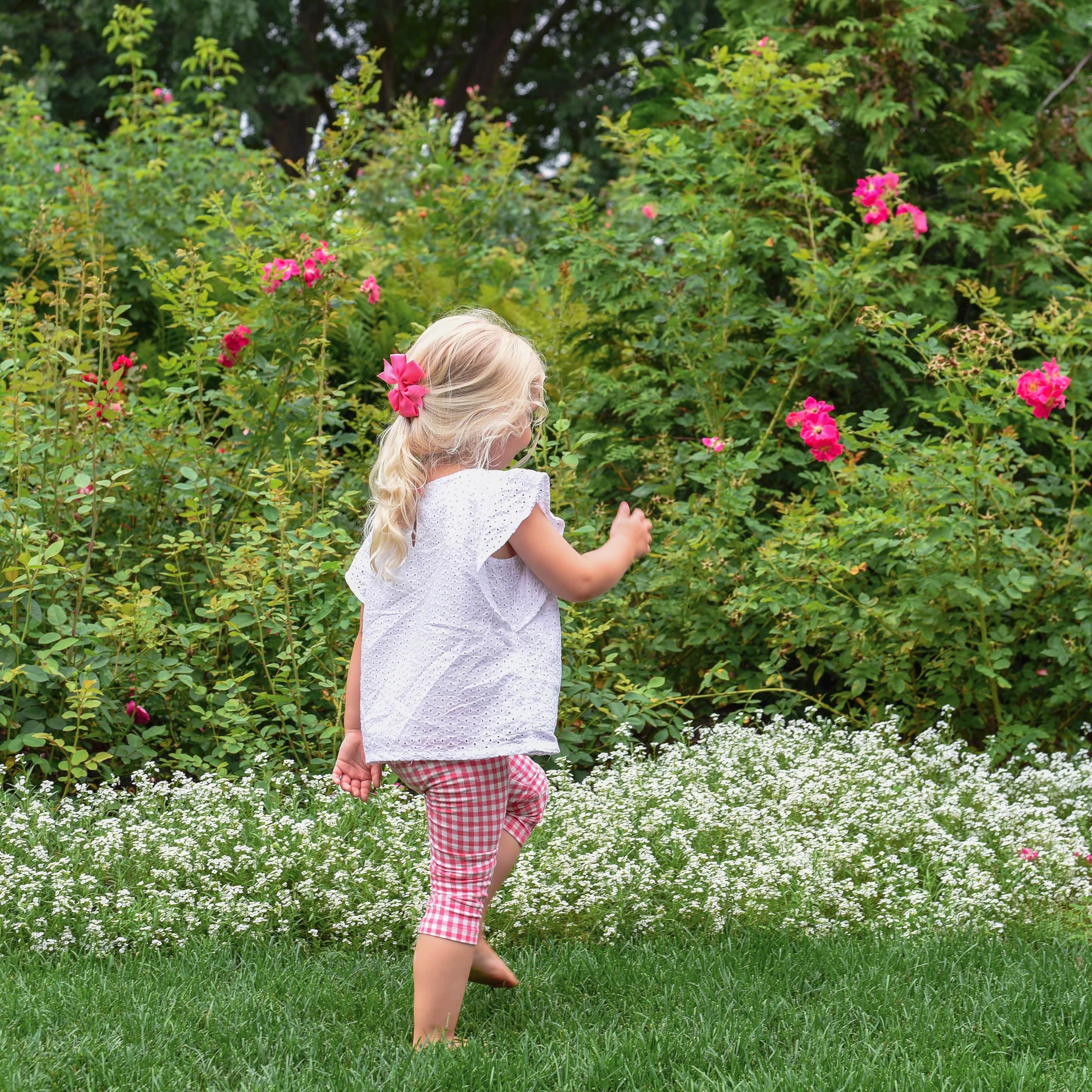 Young girl walking through flower garden