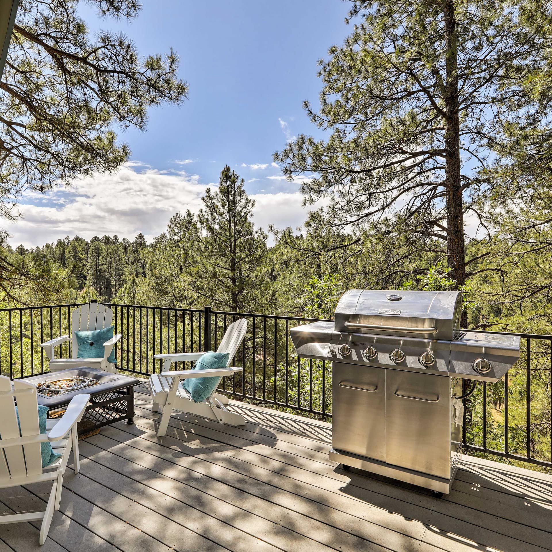 This Flagstaff vacation cabin’s deck features a gas grill, outdoor seating, and views of the surrounding woods.
