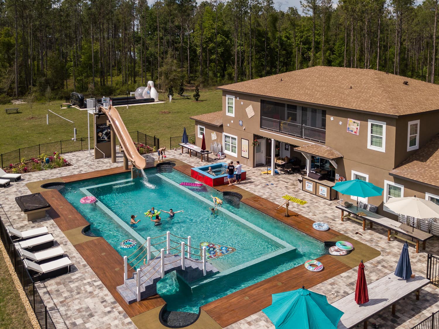 This is a photo of the backyard at the Great Escape Parkside mansion that includes a large pool, lazy river and life-size bowling.
