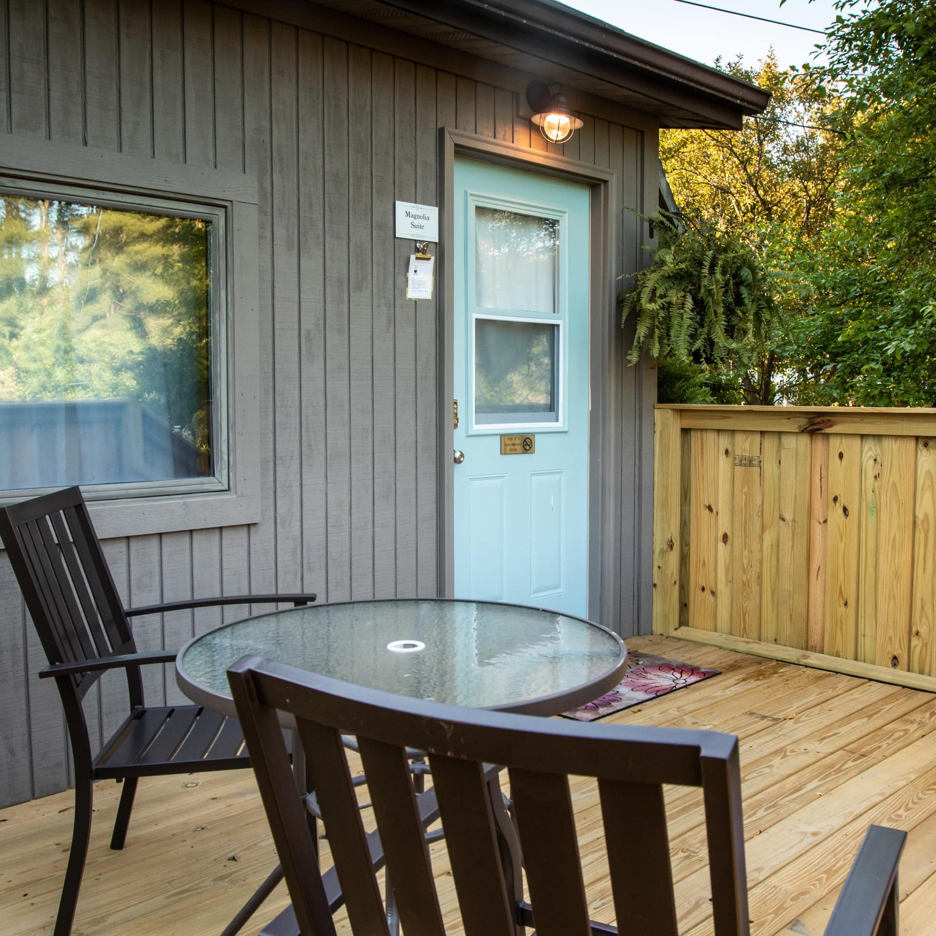 Chairs and a table sit on the deck of a cozy Ohio cottage