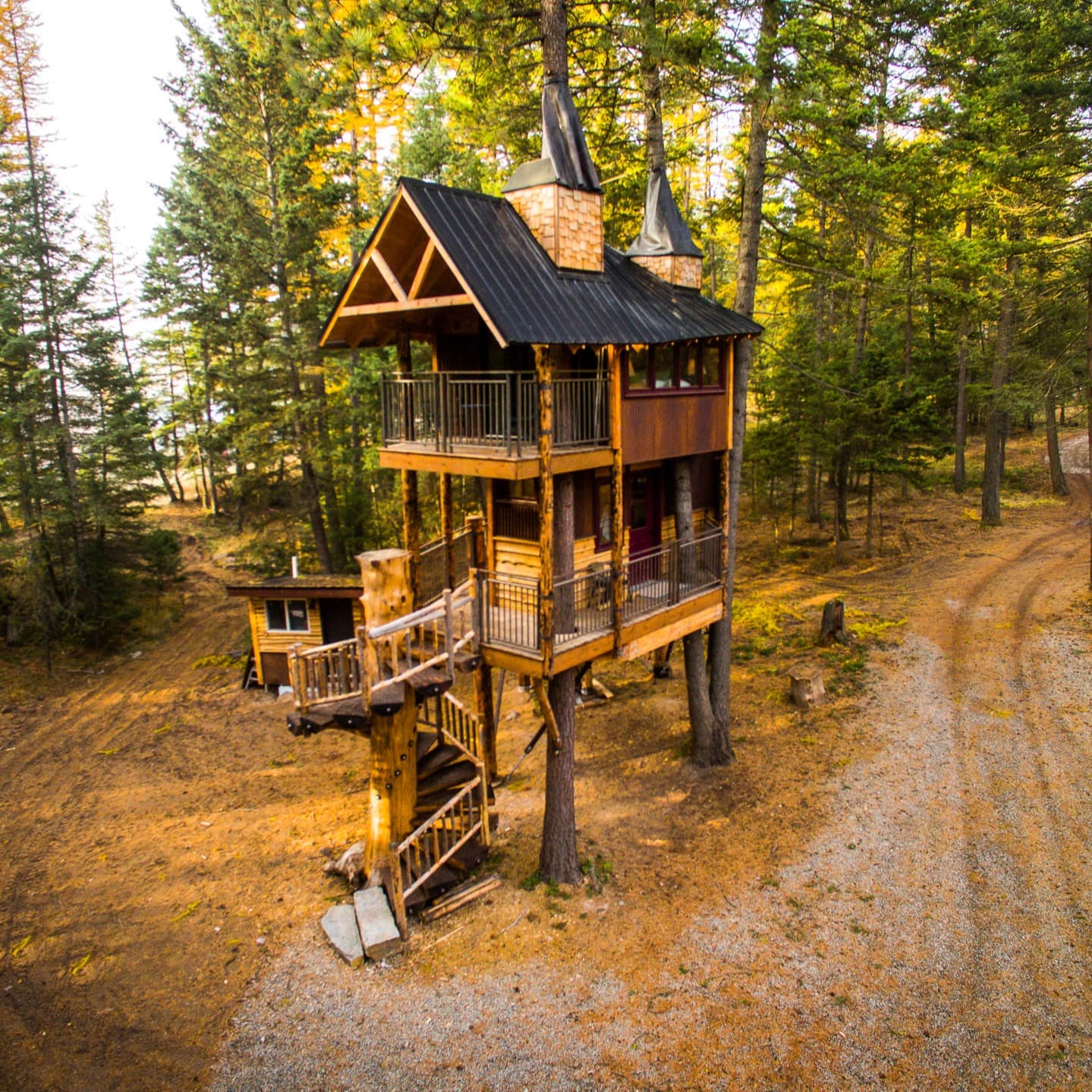 An amazing treehouse glamping rental on two levels with chimneys and spiral staircases
