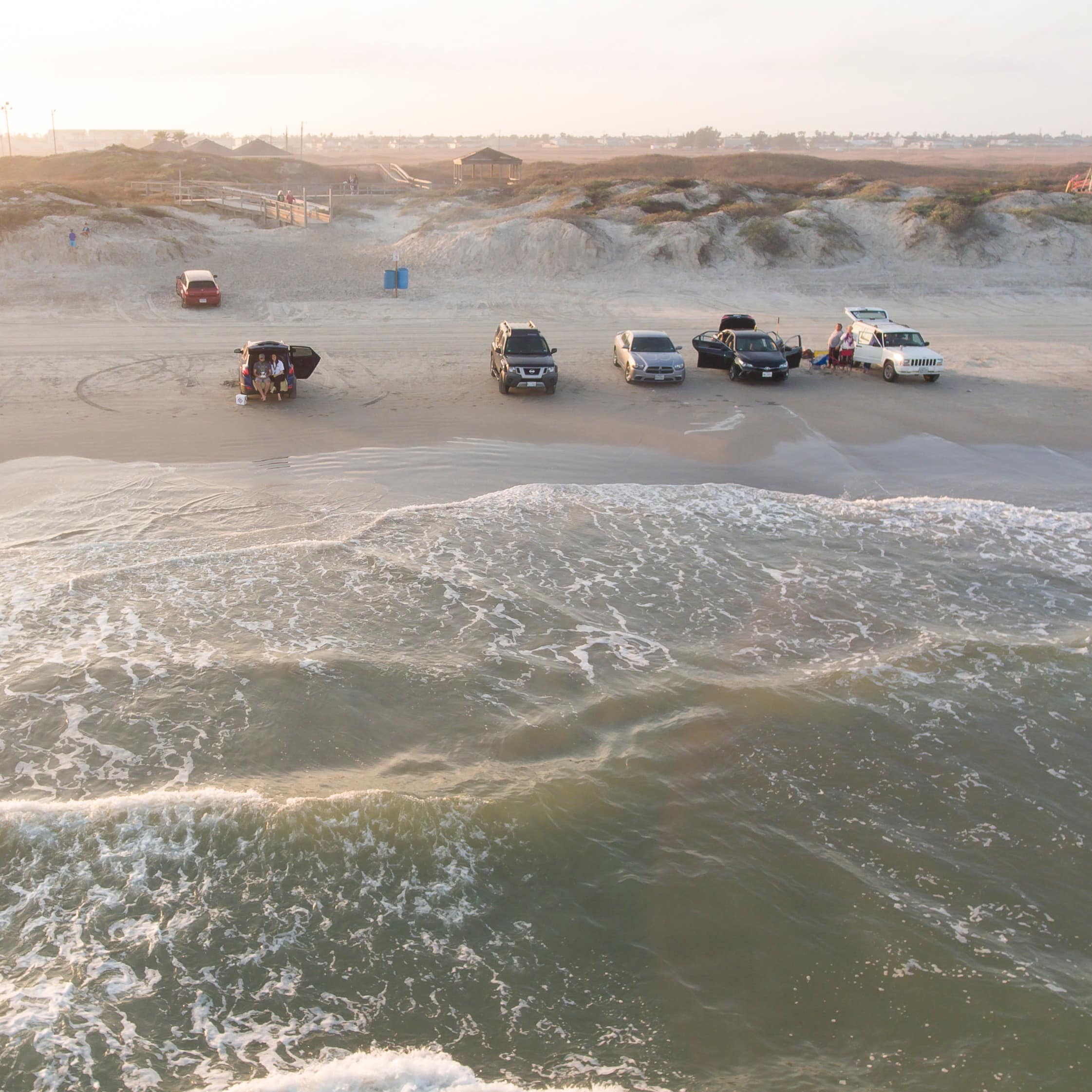 Cars line the sands of Corpus Christi, Texas, come sunset